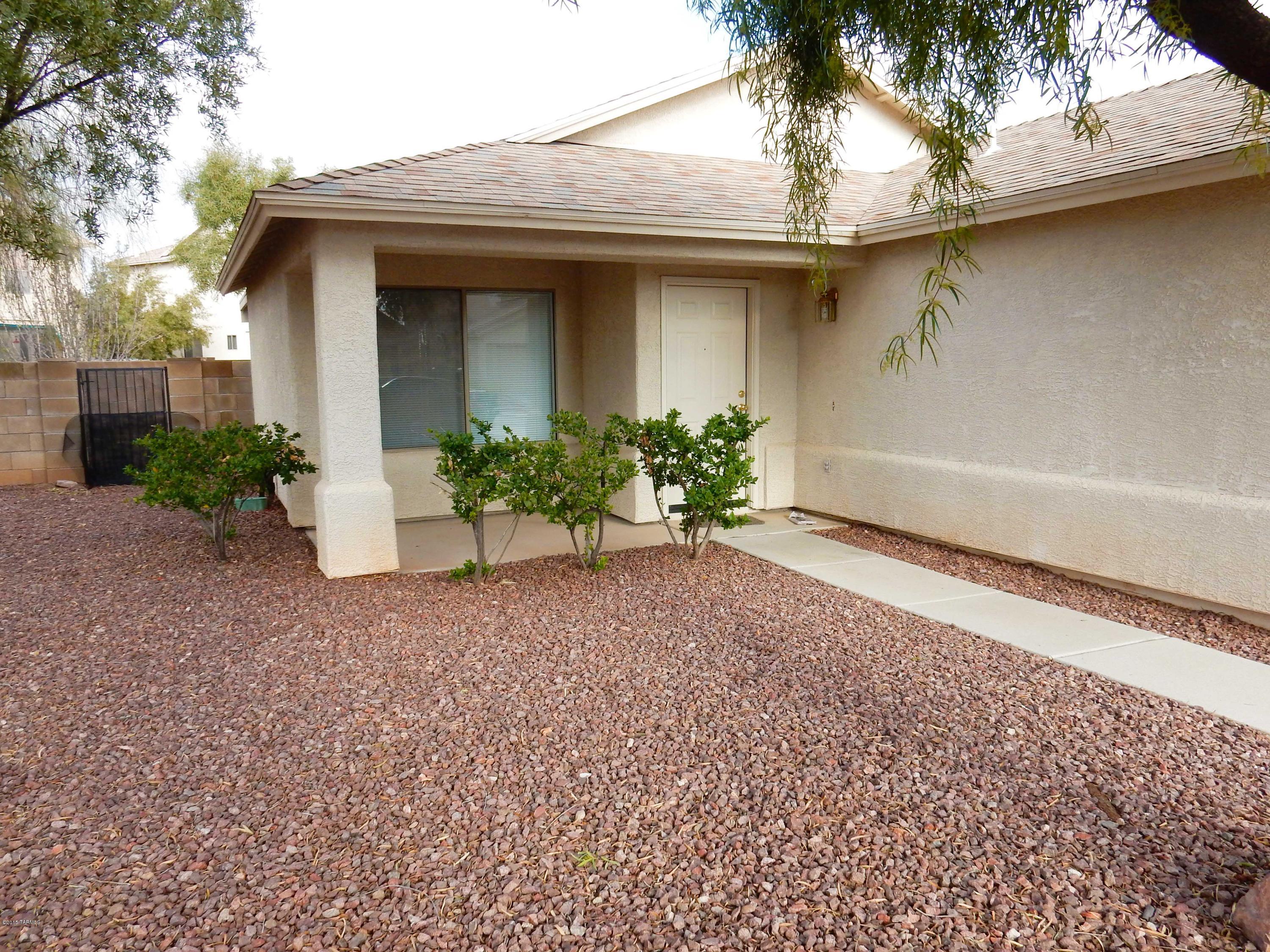 FULLY TILED! Trees Removed. Front & Back Patios! Extended 2 Car Garage. Cute as a Button 3 bedroom home w/ 1008sf in desirable Rita Ranch & Vail School District! High Ceilings throughout, open plan, no space is lost. 18 inch Tile throughout, neutral gray, freshly painted throughout, Martha Stewart Opal. Ceiling fans in living room & all 3 bedrooms. Kitchen has bar & very nice breakfast area, pantry, electric stove/oven, built-in microwave, refrigerator w/ icemaker, disposal, dishwasher, both bathrooms have windows, hallway bath has grab bars in shower/tub. Walk-in closet in master bedroom, large North-facing block fenced backyard w/ nice Covered Patio, washer & dryer hook-ups in Extended 2 Car Garage. Close to shopping w/quick access to I-10 & major employers. HVAC filters provided