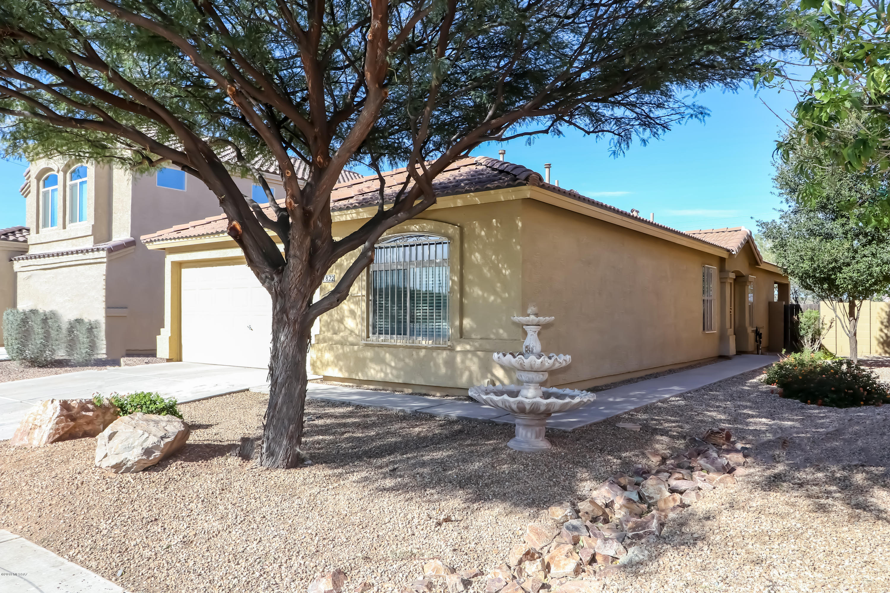 Former model home. 3 BR plus den/ 2 BA. Upgraded kitchen cabinets, SS appliances, Gas stove, Corian counter tops, Island and recessed lighting. Custom tile throughout/ laminate floors in bedrooms and den. Split floor plan, upgraded lighting, ceiling fans in every room. Cul-De-Sac Lot, Security bars, and covered patio with pool sized yard and mountain views. A MUST SEE!!!