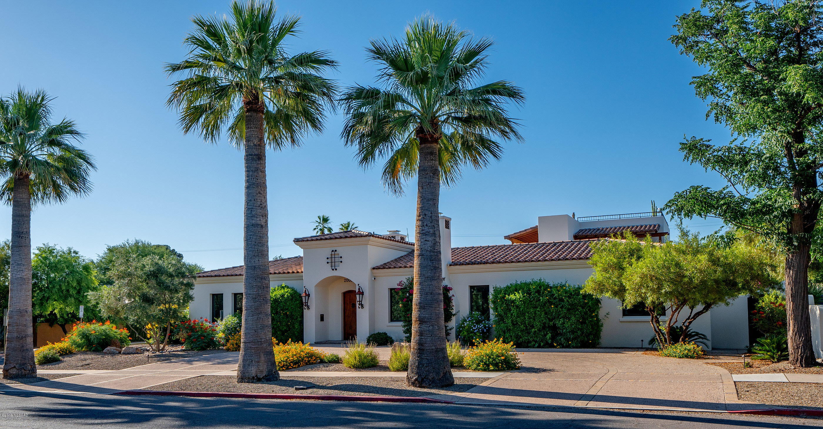 Elegant Santa Barbara style home and casita in Sam Hughes, just steps from the University of Arizona. Built by La Quinta homes in 2015 this beautifully appointed home features imported hand painted tile in kitchen and baths, custom cabinetry throughout, handcrafted lighting fixtures, natural stone floors with radiant heating. Each of the bedrooms features hardwood floors, walk-in closets and all but one with ensuite bath. In addition to the 4 bedrooms in the main house, there is also a luxurious wood paneled office/library that could also serve as a media room, if desired. The refined great room features ample entertaining space, a hidden media center, and a rare-finish marble fireplace. The exquisite kitchen has an abundance of custom storage cabinets, a Thermador appliance suite... SubZero wine refrigerator, and a lovely granite island. The comfortable living area opens onto a covered paver patio that has a gas fireplace for cool winter evenings and again has ample space for entertaining. Pass the outdoor kitchen area and enter the inviting pool area lined with citrus trees and flowering shrubs. An outdoor Mexican tile staircase leads to the independent 1 bedroom, bath and living area with kitchenette casita with two balconies. Another staircase off the casita leads to the rooftop deck when all 4 Tucson mountain ranges can be seen. A 3 car garage (with one oversized bay) and additional storage room round out this masterpiece. Please contact agent for a private showing.