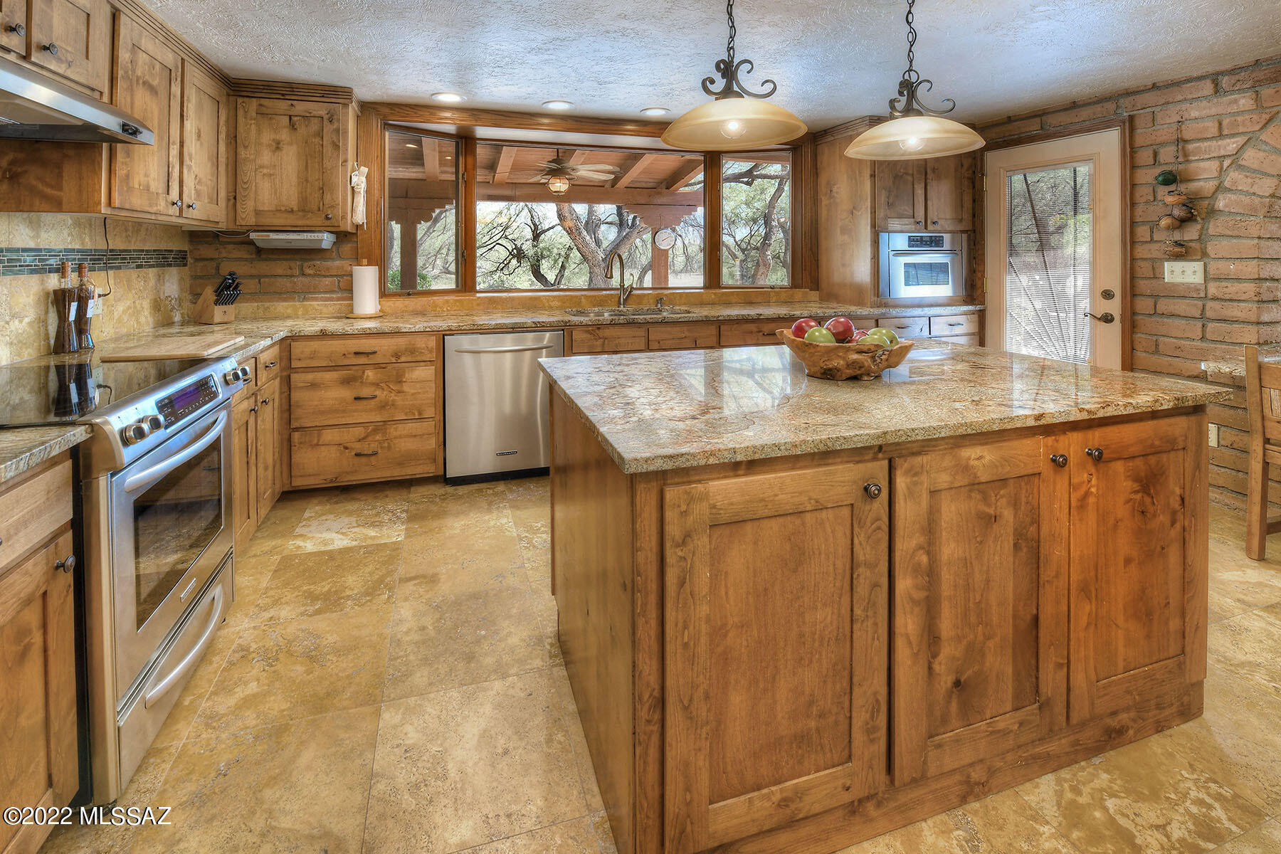 When you walk through the Hacienda courtyard, you see the calming water running down the tiered garden fountain & floor to ceiling windows. This custom 3,236 sf home sits on 5 acres of horse property with mature mesquite trees & sits above the Agua Caliente Wash. The exposed adobe block walls are paired with the high ceilings with warm wood beams in the living room. This split floorplan offers 4 bedrooms & 2 baths with an attached, oversized 2-car garage & a detached 3-car garage. The remodeled kitchen has granite countertops, alder cabinets & SS appliances. The kitchen bay window overlooks the backyard & the wildlife watering hole. The back has a full-length covered patio, flagstone flooring & wood burning BBQ pit. You'll see an abandoned well-but who knows the possibilities. Large master bedroom with exposed wood beam ceilings, fireplace & remodeled master bath with granite countertops, alder cabinets, dual vanity sinks & travertine walk-in shower. The TV room is situated next to the kitchen through the passthrough where you can sit & eat. Split floorplan with 2 bedrooms on each side of the home with the office/4th bedroom next to the master suite.  Casement windows throughout, quality construction & keeping with the Tanque Verde Valley lifestyle of dark skies & large private lots. To get to the house, you drive down a very short gravel/dirt road that connects to the concrete driveway. You pass the old barn that used to house 8 horses but now is used for storage.