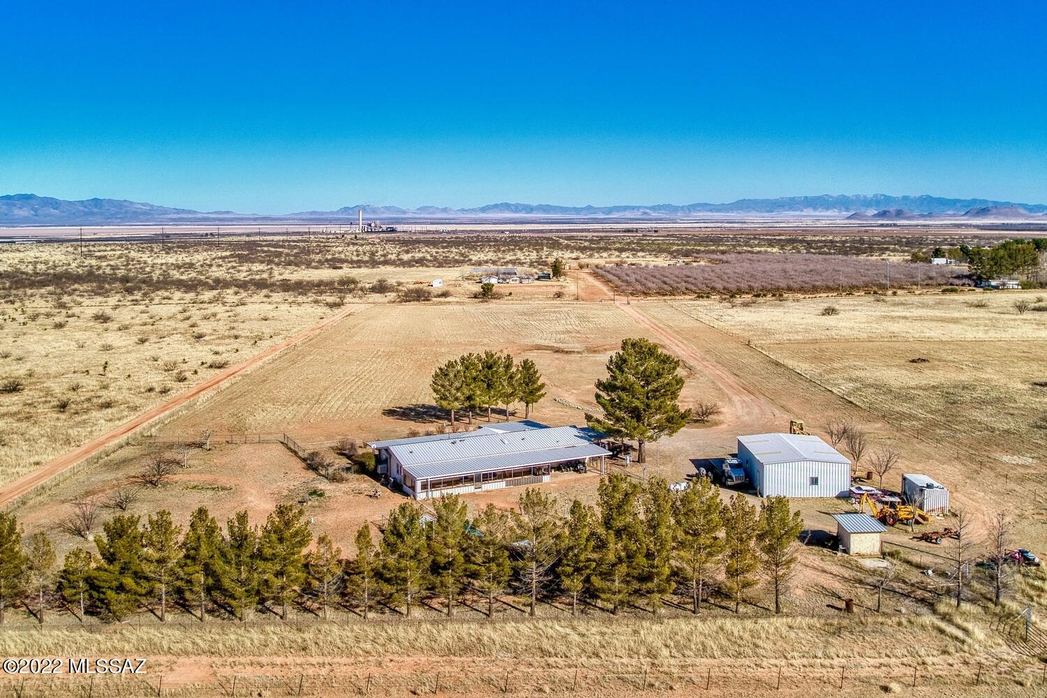 This Lovely, private retreat is situated on over 8 acres, fully fenced with spectacular views in Cochise, AZ. With a newer metal roof, and covered patio, this home has many features for outdoor and indoor enjoyment. Whether you're gathering in the spacious living room, on those few wintery nights around the pellet stove or racing around the property on your quad vehicles, your family will have plenty of fun. There are unobstructed mountain views all around. This split floorplan boasts of 4 spacious bedrooms, 2 living areas, lots of kitchen cabinet storage, an oversized kitchen island, and a formal dining area. Tons of cabinet storage inside. This property has a detached workshop, 30x40, private well, pecan trees, a chicken coup and so much more. Entire home is on concrete slab!