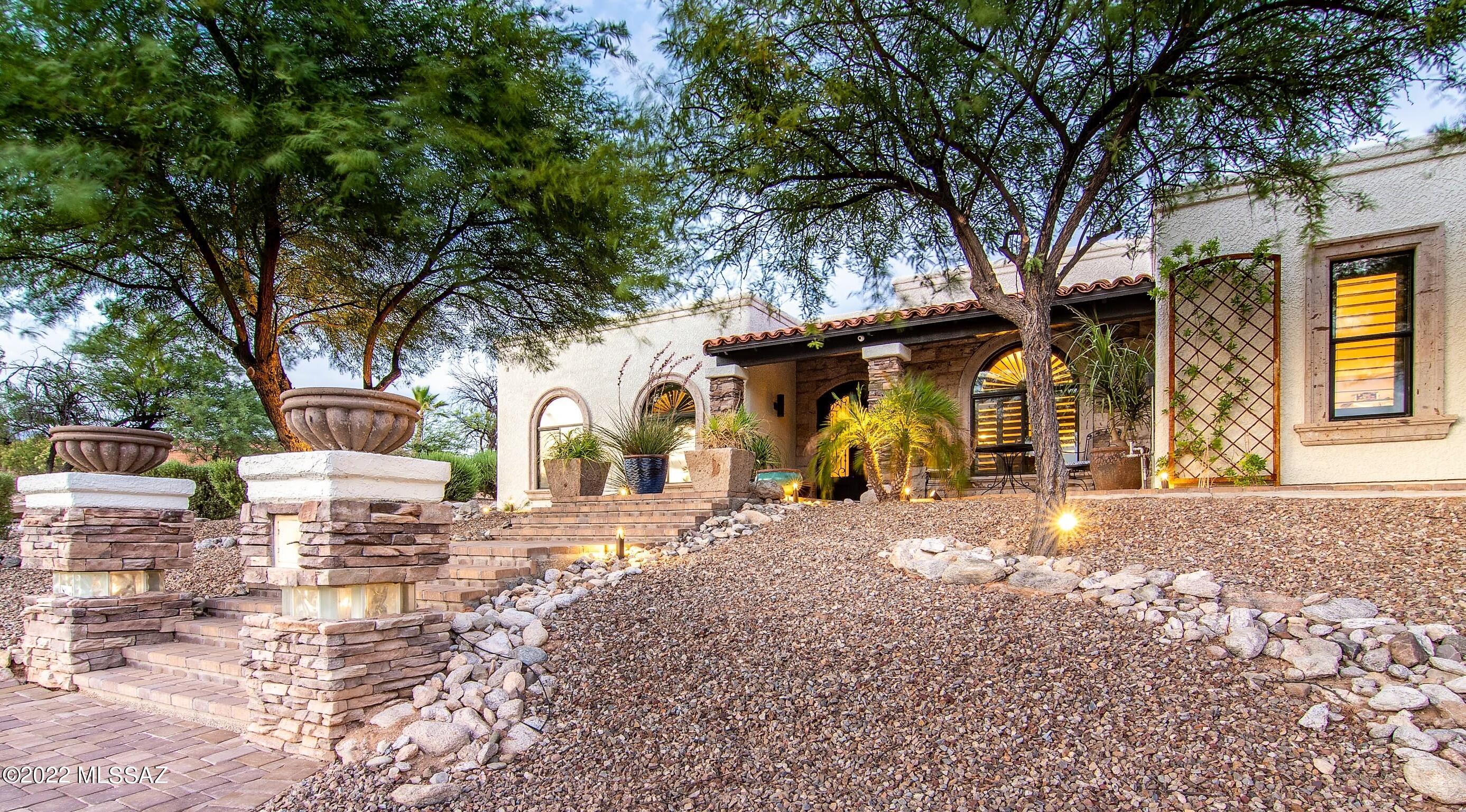 Gorgeous Turn-Key Territorial! Expanded and Re-Modeled w/ new Media Room and 1200 Sq Ft Garage. Room for RV Parking!!!  Elegant design blends modern function w/ warm, inviting character. Gorgeous curb appeal w/ generous use of Cantera Stone Accents, Paver Driveway/Patios & manicured Mesquites. Dramatic Wrought Iron Entry Doors welcome you to this charming, welcoming home. Fine interior finishes include: Travertine Floors, Alder Doors, Custom Cabinetry, Granite Counters, Plantation Shutters, etc. Permitted Media Room, Oversized 3-Car Garage & Built-in Outdoor Kitchen recently added. Media Room has W/D hookups and Full Bathroom...could be Guest Suite if needed. 8-Camera Security System. Private backyard backs to natural desert and features multiple patios & large Fountain.