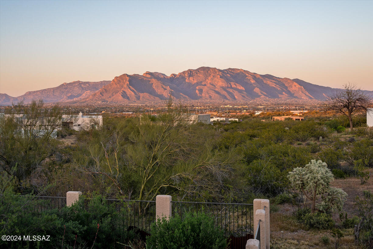 Luxurious Spaces & Dramatic Views pull you into this Spacious Hacienda, Quality Crafted in Timeless Styles of Fine Tucson Desert Living. The moment you enter the Enormous Walled-in Courtyard, you realize this is a Special, Exquisite Foothills Home. As you open the heavy, solid front door, you are aware of Quality,
Craftsmanship & High End Details. Romantic Iron Stair Railing, Rich Millwork Wooden Ceiling Beams & Exciting Brick Lined Barrel Vault Hallway Transition Ceilings all hint at a Spanish Organic Warmth. Large gas fireplace graces the open spaces of the Dramatic wood beamed
ceilinged living room and showcases the east facing windows allowing stunning views of the Catalina Mountains, City Lights and the Soft Rolling Desert.