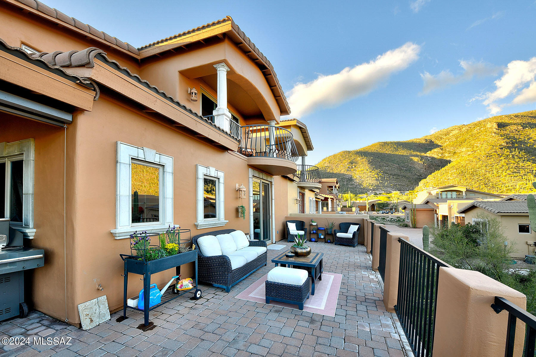 Enjoy panoramic views of the Catalina Mountains during the day & sparkling twinkling city lights from the huge patio of this exquisite 4 BD, 4 BA home! All living areas, kitchen, & large primary suite on the main level. Great room w/ sweeping ceilings is great for entertaining. Kitchen features granite countertops, alder cabinets, & windows w/ view to the mountains. Master suite has dual vanity, shower & tub, large walk-in closet, & opens up to backyard patio. Downstairs room has a wet bar & makes an excellent living space or office. Gorgeous hardwood flooring & travertine throughout. Upstairs bed has en-suite bath & 2 additional beds w/ jack & jill bath. 2 covered patios upstairs. Meticulously maintained home, water heater installed in 2023 & heat pumps were installed in 2019 & 2023.