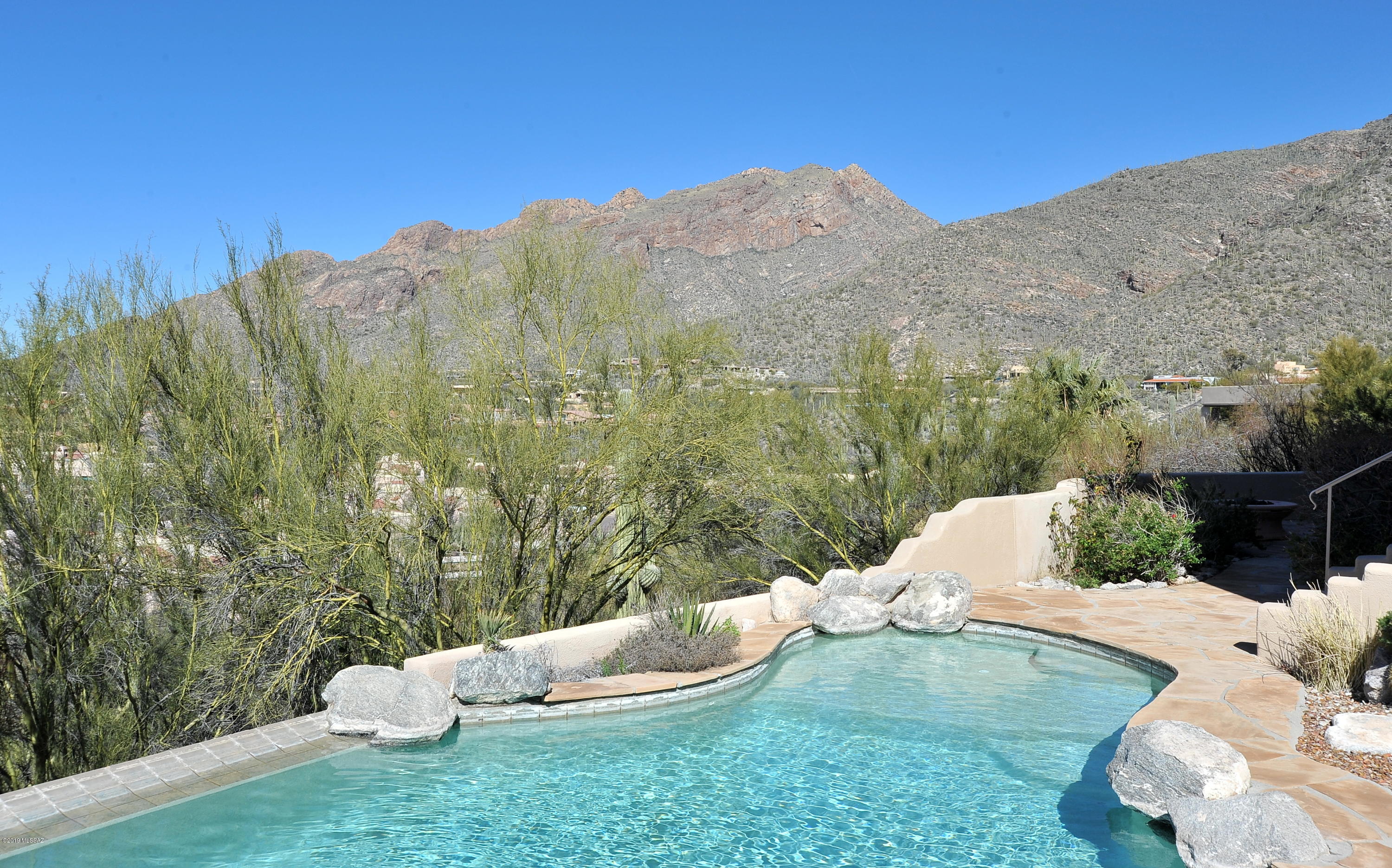 Range Pricing 790,000-825,000 INCREDIBLE VIEWS of lights & mountains from every window, every patio, & every angle that you can imagine!!  If you want breathtaking vistas every moment of the day & night...no matter which room you are in, then you need to come look at this fantastic custom built home. 3000 square feet of elegant living on the entry level with the Great Room, Master Bedroom Suite, 2nd BR w/ private bath,  Dining Room, and spacious gourmet kitchen w/ adjoining powder room. The lower level includes the unique guest quarters floor plan with a jack & jill bathroom, large guest bedroom, comfortable sitting/family room, and the amazing office with floor to ceiling builtin bookshelves - this room could be used as the 4th bedroom & Seller will add a closet w/ acceptable offer. A closet will be installed with an offer that is acceptable to the owner)Every room on the lower level flows to the beautiful patio overlooking the negative edge heated pool & spa accented with a rock waterfall & adjoining putting green. Every window & door also shares the same INCREDIBLE VIEWS!!  Many more custom features in special home -- the new owner will really enjoy the $19/month electric bill  to run the entire house  w/ it's own roof top solar system!