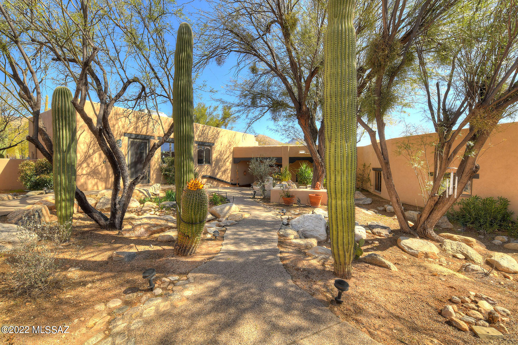 Charming Southwest Adobe home nestled on 2.6 acres in the Tanque Verde Valley. Enter through landscaped courtyard w/separate entrances to Guest Wing, Garage & Main home.  Great Room offers captivating mountain views, beehive fireplace, wood plank ceilings & adjoining dining area.  An Inviting back porch is located off the Great Room. Kitchen features large island, separate eating area & outdoor sitting area & spa.  Master bedroom w/sitting area & outdoor patio, 2 additional bedrooms & large bath are part of the main house.  A separate guest wing contains 2 bedrooms & a bath along w/a separate HVAC system.  A powder room is also located off the main living space.  The serene outdoor areas make it difficult to leave.