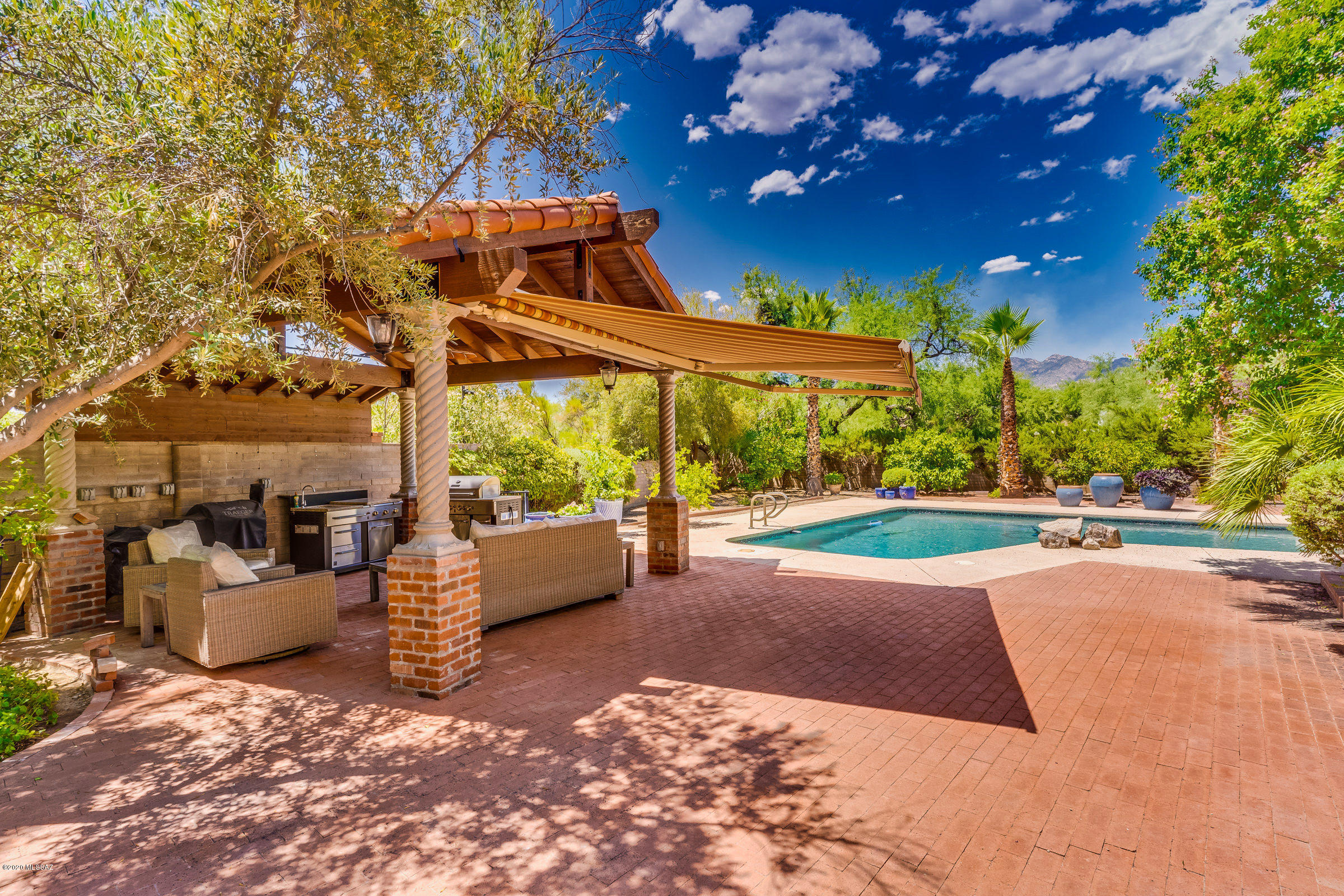 Rare find in Tucson Country Club Estates! This elegant mid-century home has been lovingly cared for and has recently had a complete kitchen remodel. Lush landscaping is apparent the minute you enter the grounds and with the circle drive and 4-car garage there is never a shortage of parking when entertaining. This home is designed to provide a comfortable, yet elegant lifestyle. Three separate living/entertaining areas and a formal dining room perfect for large dinner parties. The home boasts 5 bedrooms and 5 bathrooms one of these is a mother-in-law suite with a separate entrance that features a living room and bedroom. The laundry room is enormous and functional. Tranquility awaits as you enter the amazing backyard. Mature trees, a sparkling pebble-tech pool, a ramada with outdoor kitchen and an abundance of fruit and citrus trees.