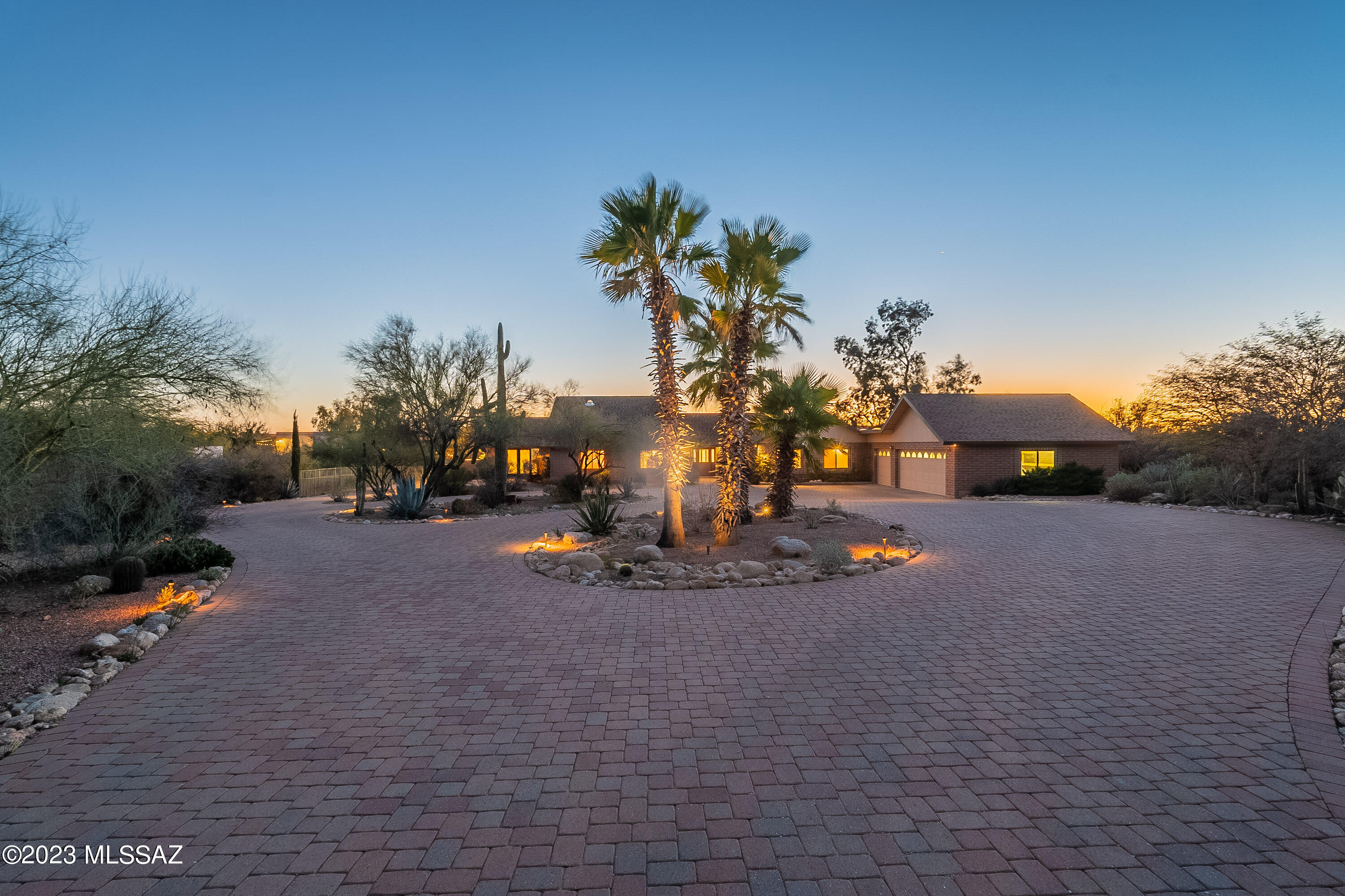 Fantastic indoor/outdoor living on one of the best lots in Shadow Hills, this 4BR, 3ba home boasts a 3-car garage, two purpose-built office spaces, a pebbletec pool, and one of the most dramatic paver driveways you'll see anywhere.  Sitting far back from the end of an already quiet cul-de-sac, this home is one of the more secluded-feeling settings one can find, and yet so close to all the conveniences.  Perfectly sited to soak in winter sun, the southern-oriented rear patio, pool, and yard overlook a natural wash area, giving one a real sense of privacy.  Inside the home, a huge-feeling series of living areas--nearly 60 linear feet from one end to the other, with high ceilings and a gallery of south-facing windows and doors--filled with winter sunlight through the day.  (see ext remarks... ...video, and virtual tour).  
The size and feeling of openness in the three contiguous living spaces cannot be understated.  With the winter sun beaming through the length of these spaces, it isn't hard to imagine hosting the largest of gatherings of friends and family here, passing in and out of slider doors on each side of the long covered patio... or for just enjoying quietly in the day-to-day, with the combination of the lush plantings, the glimmering pool, and the verdant bordering area forming an ideal backdrop.  There are really three living areas here: one at the center of the home, one that opens onto the kitchen, and an additional living room that was added on to the eastern end of these, with double doors opening north to a front patio.  With these front french doors open to the mountain-view patio in front, and the slider doors providing access to the extra-long covered patio to the rear, there is a potential here to host that will be rare in a continuous space like this without steps.


The primary bedroom enjoys winter sun and space, with high ceilings of its own, and garden tub that overlooks the backyard through a bay window.  A front bedroom, off the living area, is a perfect place for a large home office or, with mountain views and an adjacent bath, a bedroom to impress guests.
The other two secondary bedrooms boast mountain views of their own.  Not to be overlooked are the two office spaces, each outfitted with extensive shelving and desk set-ups.  The larger of the two is set off on the western side of the home, far from the living area, but just a few steps down the hall from a bathroom.  Situated as it is, a fantastic work-from-home office that one can shut the door on and leave behind at the end of the work-day.  The other office, though much smaller, has an enviable view to the north, capturing mountain views and that impressive, luxurious pavered drive.