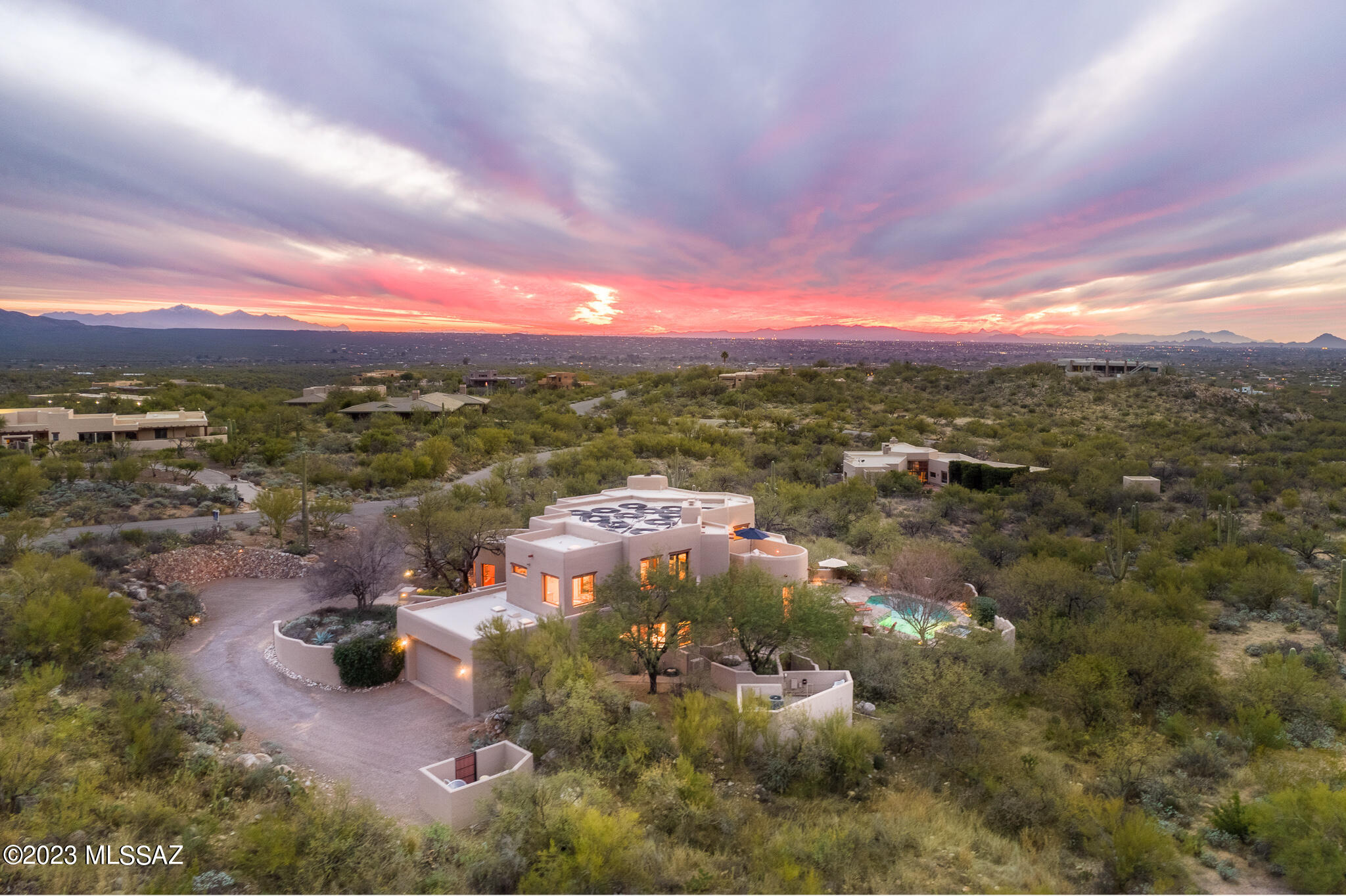 Any Tucson Native will tell you, there is no part of Tucson more beautiful than the Tanque Verde Valley! Covered in lush mesquite bosques, tranquil Riparian areas and peaceful saguaro covered hills, you feel a sense of calm that only nature can bring. Residents love the rural ranch lifestyle, yet enjoy every  modern convenience – shopping, dining and Country Club activities, all just a short drive away! Redington Ranch is without question one of Tucson's premier gated communities, attracting the sophisticated Equestrian buyer looking for an Arizona Ranch without all the work. The Ranch offers a community pool, clubhouse, tennis court, private lake, and allows owners the ability to board their horses in a
professionally managed, 20 stall barn with all the equestrian amenities one would expect, including a full time Ranch Manager on site and endless miles of riding trails and wash access. As you approach this stunning, one owner, Ron Robinette designed Santa Fe masterpiece, it becomes apparent that the owners carefully selected the placement of the home on the prime 2.7 acre view lot so that the large picture windows capture the jaw dropping views of the mountains, private canyons, desert landscape, and twinkling city lights. The handcrafted front doors open to the grand foyer with soaring ceilings and gallery walls ideal for displaying a large art collection. Arizona Red Flagstone from the Mogollon Rim is featured on the main level floors and outdoor patios. The gourmet kitchen features custom mesquite cabinetry, a gas cooktop, center island, walk in pantry, and charming hand painted Mexican tiles. Dramatic walls of windows, stunning gas fireplace with custom metal screen, and beamed and wood planked 20' ceilings accentuate the stunning living room.  Guests will enjoy 3 en-suite guest bedrooms, 2 w/private entrances. Upstairs features a private library/home office with beehive fireplace and private viewing deck overlooking the pool and city lights. Adjacent to the library, the Owners' Bedroom suite features a gas fireplace, French doors, outdoor space, and it's own private elevator. The bathroom features double vanities, spa tub, walk in shower, custom hand painted Mexican tiles, and an enormous walk in closet. The resort like backyard with expansive covered patios, built in BBQ grill, kiva fireplace, copper fountain, pool and spa, mature landscaping, and breathtaking views make this the perfect full time home or vacation retreat in the desert. Complete with Tesla Charging Station, 2 newer HVAC systems, 2 newer hot water heaters, and central vac. Available at $1,300,000 unfurnished. At $1,400,000, the home conveys with all furniture and accessories, excluding artwork and personal contents, creating a turn key Arizona showplace.