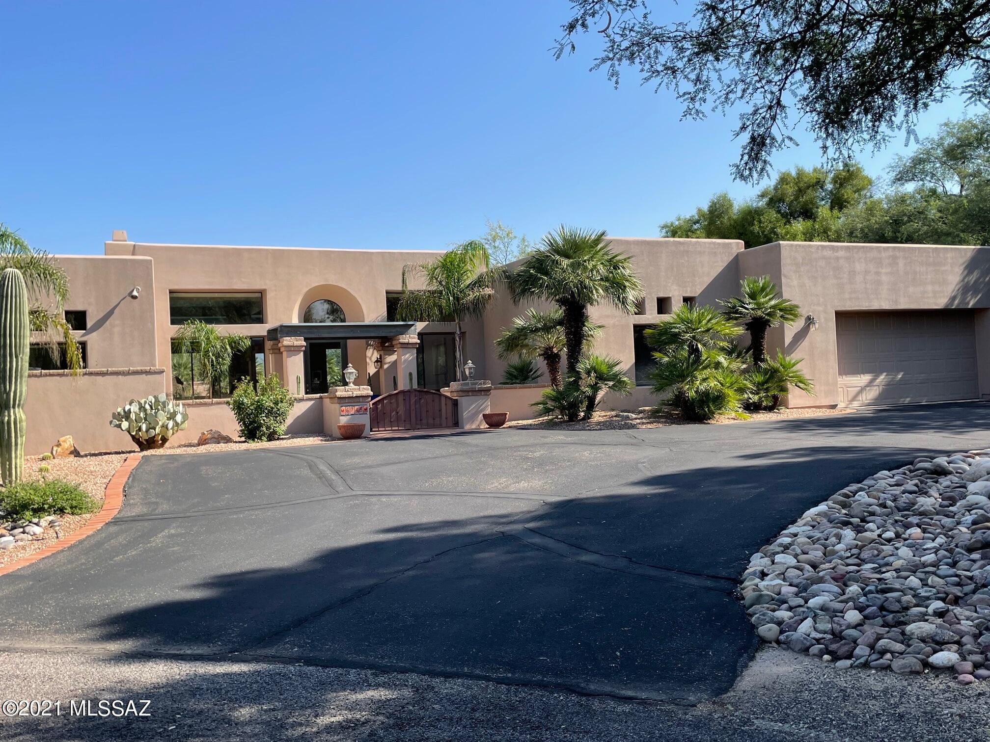 Located in the much desired Country Club Estates, this charming home offers many extras.  High ceilings, floor to ceiling windows (letting in lots of natural light), beautiful brick flooring in living areas, 2 fireplaces, built-in BBQ, large terraces and your own private entertainment area with pool and beautiful gardens in the back of the property, with incredible views of the Catalina Mountains.  The Queen Palms surrounding the property only add to the charm of this unique home.  The gourmet kitchen boosts tavertine counters, kitchen aid double   ovens, Dacor cooktop, along with GE Monagram Fridge.  Split floor plan, and two great rooms, make this home an entertainers dream.  OPEN HOUSE 11-1 ; SAT 10-16 and SUNDAY 10-17.