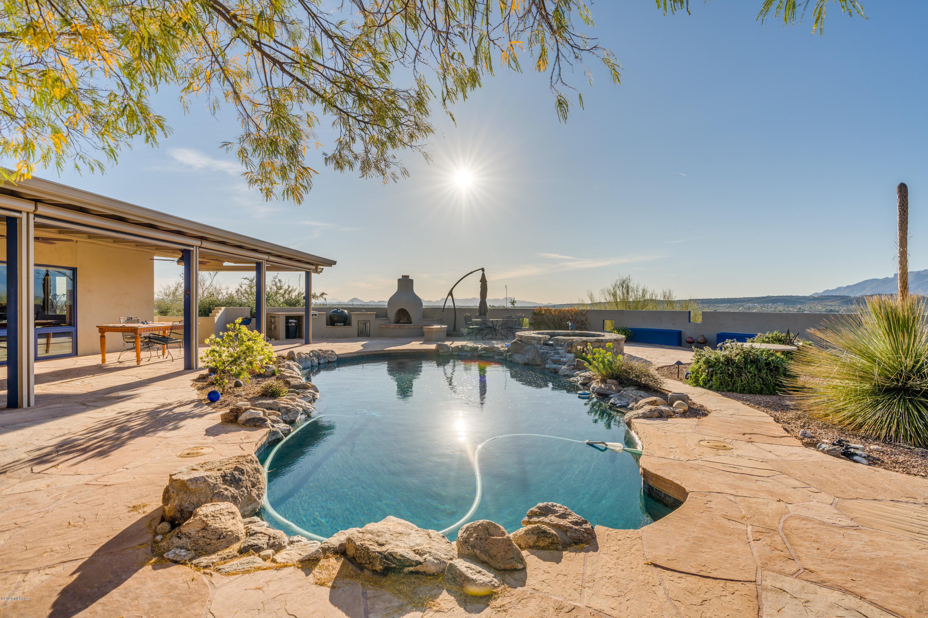 Two HOMES for the price of ONE in the Tanque Verde Valley with many uses...Multi-generational living, AirBnb, or Office/Studio. This 3.04 acre hillside property has panoramic views of the mountains and cityscape.  Enter the main home to view the artistic flare which makes it one of a kind. The kitchen boasts custom hickory counter tops, solid wood cabinetry with hand-forged hardware, instant hot water, custom island with pop-up electrical feature on wheels.  The living room & den feature double sided fireplace, custom built shelving and sliding doors to pool.  Large covered patio with automatic shades and sparkling pool, gas fireplace, horno, firepit, rain harvester and custom sundial.   Remodeled Guest House 1160 sf 2 BR 2 BA 2 Car Garage with views