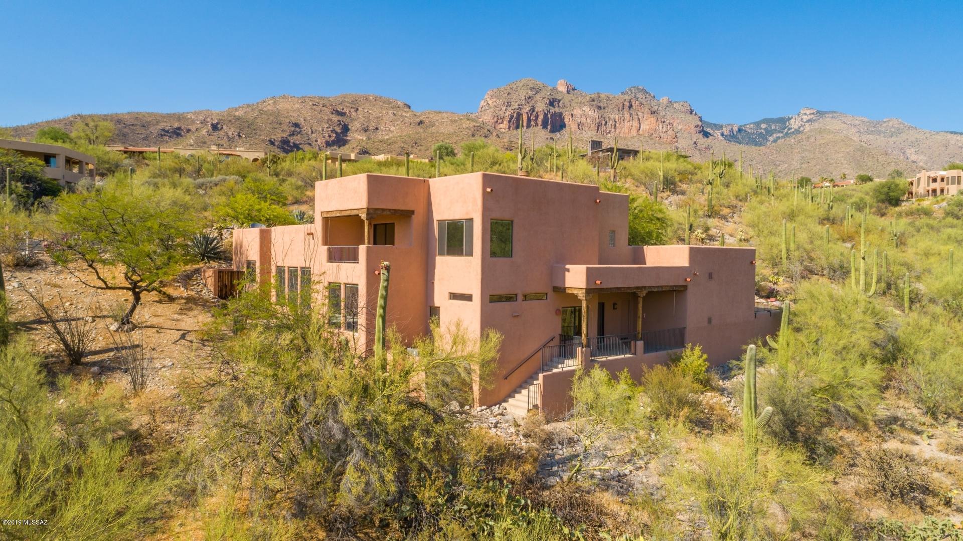 Range priced $500K- $510K. Contemporary home located in manned guard gated Sin Vacas! Perched high on a hill, take in breathtaking mountain & city views! Enter through courtyard-perfect for entertaining. 4 bed/3 bath home features high ceilings & huge picture windows. Kitchen has stainless steel appliances, built-in refrig, spacious pantry & opens up to family room with fireplace. Fully updated master bath w/ dual vanities & BIG walk-in tiled shower. Large master bedroom complete w/ cozy fireplace. Bedroom #4/Office has its own private balcony w/ amazing views. Beautifully landscaped with mature trees & surrounded by pristine natural desert. Enjoy cost saving solar panels! Unbeatable location close to La Encantada shopping & all the top restaurants. Best deal in Sin Vacas!!!