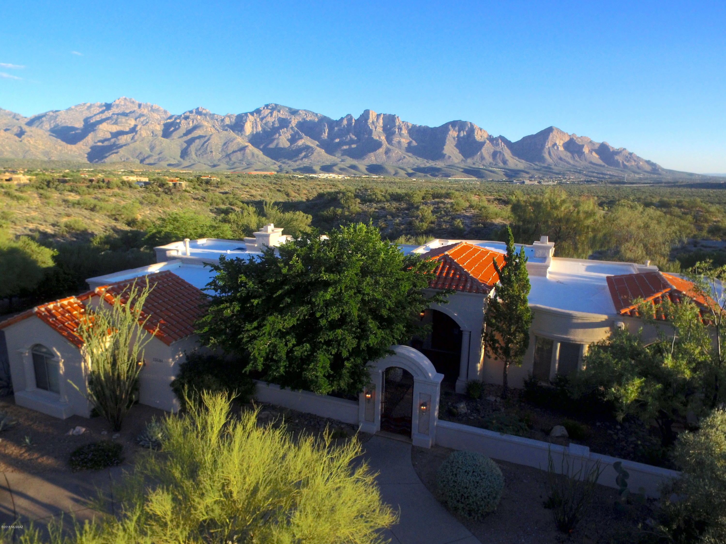 Majestic Mediterranean home located at the end of a cul-de-sac on nearly an acre of land in highly sought after Estates at High Mesa, an elevated small gated custom home community in Rancho Vistoso. Take in the magical setting that surrounds you, with spectacular panoramic views of the Catalina mountains, vast natural desert landscape, stunning sunrises and sunsets, and city lights at night. From the moment you enter you are surrounded by sensational views and upscale finishes throughout. This 3,669 SqFt home features 3 bedrooms, 3.5 baths, 4 gas fireplaces, and an extended 3 car garage with built in cabinets, workbench, and separate storage room. Enjoy gathering with friends and family in the living room with floor to ceiling windows that capture the expansive picturesque views. Featuring wood beam ceilings, oversized fireplace, built in entertainment center, and a wet bar that is perfectly placed when entertaining guests in this sizable space. Speaking of entertaining, the kitchen is a chefs dream come true. Featuring gorgeous granite countertops, double sink, large island with prep sink and additional garbage disposal, microwave, 6 burner gas range, double oven, two dishwashers, and large walk in pantry. Gather in the dining room for a formal feast with custom built cabinetry to make it complete, or dine in the kitchen with magnificent mountain views. Relax in the family room cozied up to a fire, or escape to the spacious master suite for a private retreat where enlarged windows capture the breathtaking views. The master suite also features a private patio, built in entertainment center with extra storage drawers, dual fireplace, separate sitting/workout room, dual walk in closets, luxurious bath with fossil stone countertops, soaking tub, and walk in shower. The powder room and large office which features a built in desk and private patio off of front courtyard, are located close to the master suite and living room. Beautiful travertine floors run throughout the main house, with wide hallways leading to a spacious bedroom with en-suite bath. Large laundry room offers a tremendous amount of counter space and built in cabinetry for ample storage, with garage access. Second master suit features a sliding glass door leading to the back patio, large walk in closet, and a big bay window capturing the captivating Catalina mountain views. Ensuite bath has a walk in shower and back patio access. Backyard is surrounded by spectacular Views! Views! Views! Featuring a large covered patio, outdoor kitchen, fireplace, and heated shower, spa and pool, with water falls and fire bowls that make it exceptionally cool. Whether you are entertaining or relaxing, this truly is Arizona living at its finest.

Exterior of home painted, Sept. 2018. Flagstone patios sealed, Sept. 2018. Roof painted 2016. Roof has been semi-annually maintained (Spring and Fall), Fall maintenance completed, Sept. 2018.
Listing agent is related to owners.
