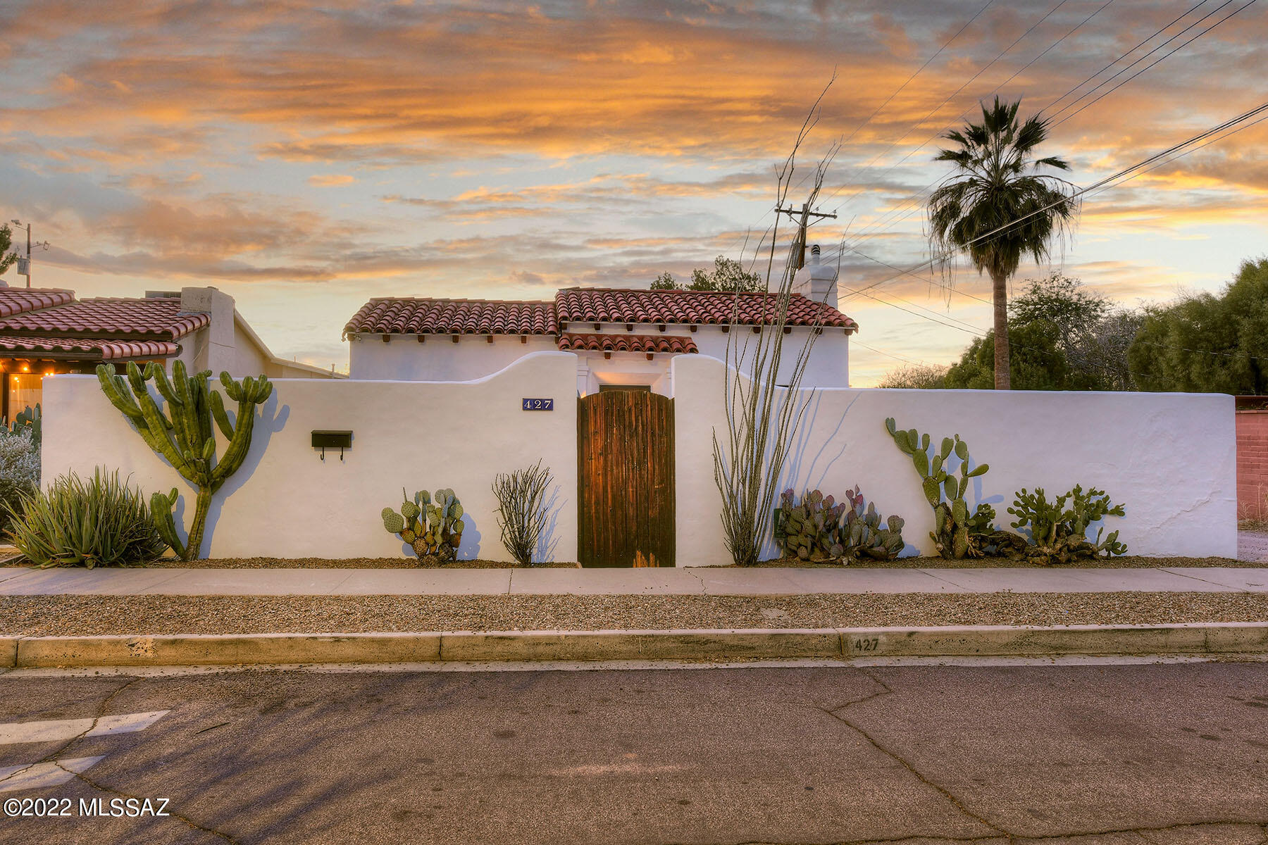 Sam Hughes Spanish Mission home originally built in 1936.Beautiful hardwd flrs & colored concrete flrs, hi,wood-beamed ceilings in the living rm, w/ nichos & heatilator opens to updated & remodeled kitchen with large eat in area.  Unique punched metal ceiling & backsplash,vintage main bath has new vanity. 2nd bedrm has sittingrm/office or could be used as a den. Sep downstairs bedrm has separate entrance & ensuite Jack & Jill bathrm perfect for sharing or using as office. Backyd has BBQ, concrete patio, large  carport, extra storage & separate gst home. Gst hse has garage style patio dr, colored concrete flrs, laundry,1 bedrm,1 bath & kitchen w/granite counter tops.The home & property is surrounded by a large masonry wall w/ electronic gates & privacy! Off St parking! walk to Flora's. The home & property is surrounded by a large masonry wall with electronic gates & privacy!  Off Street parking! Walk to Flora's Market, Himmel Park & UArizona!