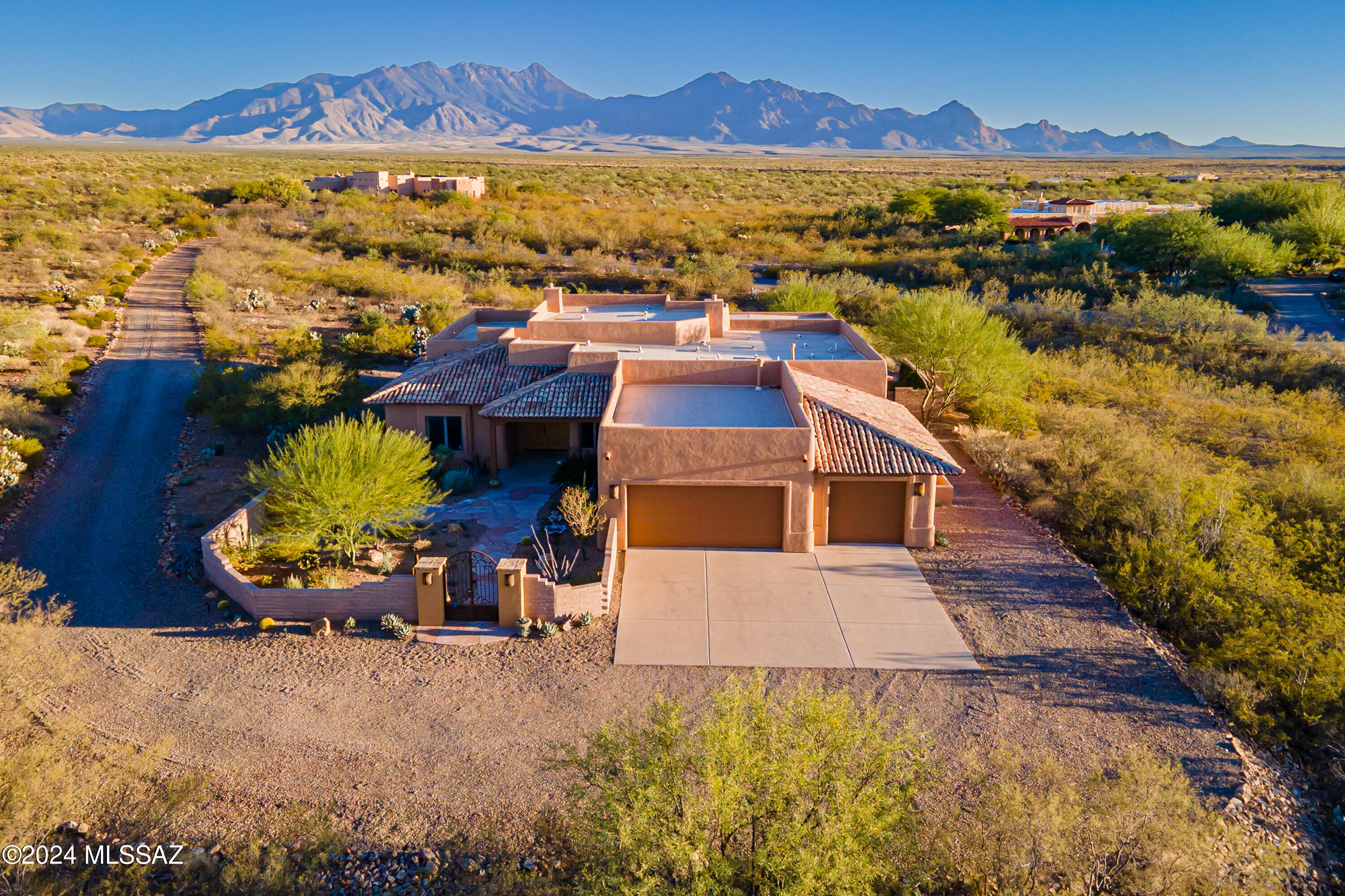 This stunning home, nestled on over 4 acres of beautiful Arizona desert, blends modern luxury with the serenity of nature. The property features a completely walled-in front courtyard, highlighted by a new flagstone walkway and patio, perfect for seating in front of a newly crafted fireplace. A newly installed water fountain adds a tranquil touch, while all-new desert landscaping and a PVC irrigation system ensure low-maintenance beauty throughout. Entering through gorgeous wood doors, you are welcomed by tile floors, high ceilings, and expansive windows that flood the space with natural light, framing incredible views of the surrounding mountains. The open floor plan includes a large, modern kitchen with a new sink and plumbing, a breakfast bar, and a cozy nook. The great room features a large fireplace, creating a warm and inviting atmosphere. A spacious media room and guest bedroom offer the perfect space for gatherings with family and friends. The primary bedroom and bath are equally impressive, featuring a fireplace and a reading area for ultimate relaxation. The home has been thoughtfully updated with all-new light fixtures, ceiling fans, toilets, a hot water heater, water softener system, under- and over-cabinet lighting, and new ignitors in the fireplaces. Step outside into the backyard, where you'll find new travertine decking extending from the covered patio around the custom saltwater pool with a waterfall feature, controllable via an app on your phone. The travertine also leads to a gas fire pit seating area, perfect for evening gatherings. Surrounded by new slump block and custom wrought iron fencing, the backyard boasts new landscaping, a PVC irrigation system, and solar landscape lighting, enhancing the peaceful desert setting. With unparalleled views of the mountains, Arizona skies, and sunsets, this home offers the ultimate in resort-style living. The large garage, complete with an expansive storage area, adds convenience to this dream home. In 2023, the home was updated with stucco repairs and fresh paint on all the wood features completed to perfection. This home is truly ready for you to move in and enjoy your very own Arizona paradise.