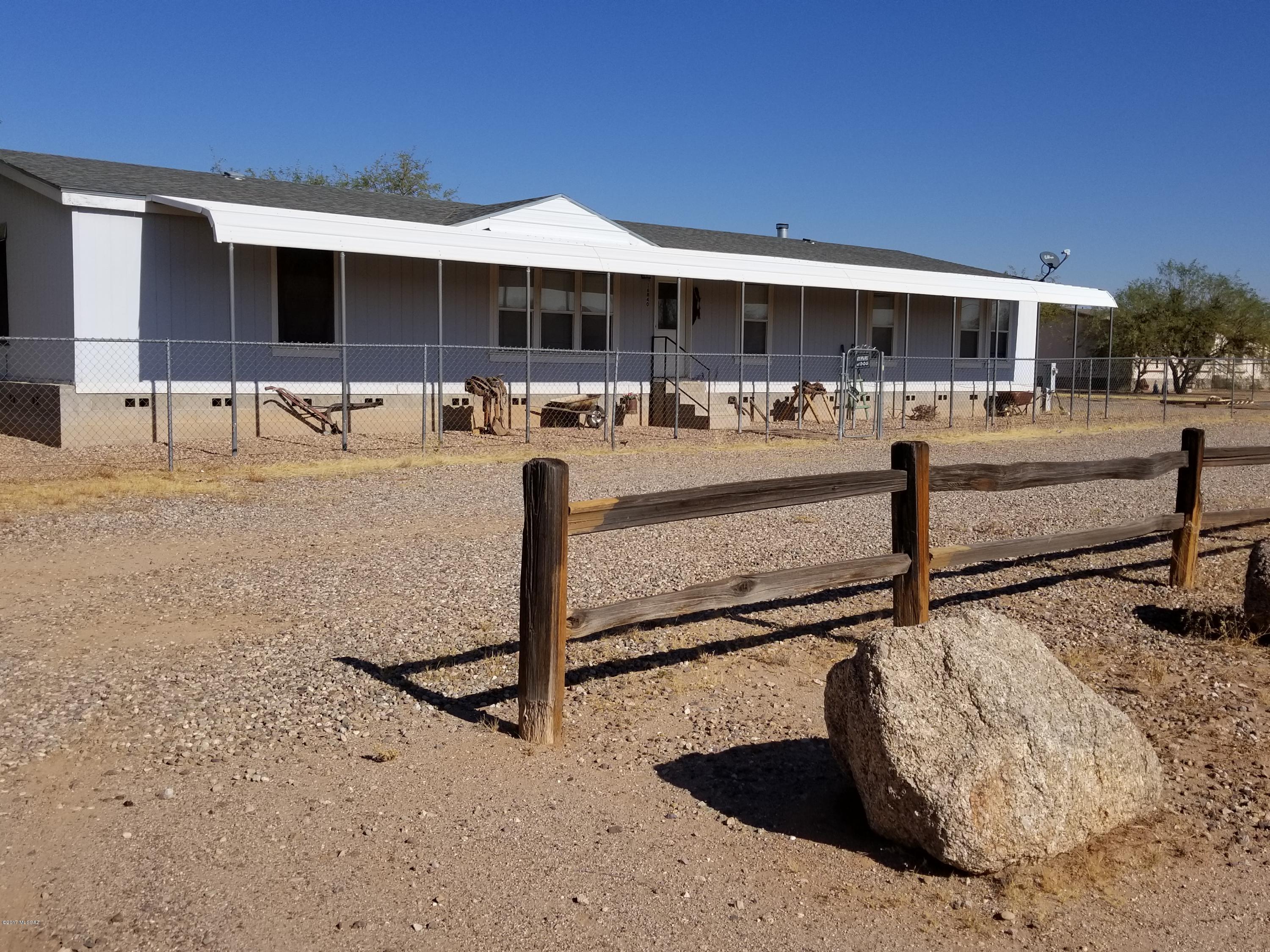 2004 4 bedroom 2 bath Manufactured home in popular area of Avra Valley. Large flat acre low care graveled lot with separate 2 car garage and additional RV hookup for water and sewer. Large open kitchen with island bar, with separate dining area. Open split floor plan.  Has laundry room and large master suite with garden tub and separate shower. Can be horse property.  New Roof 2012