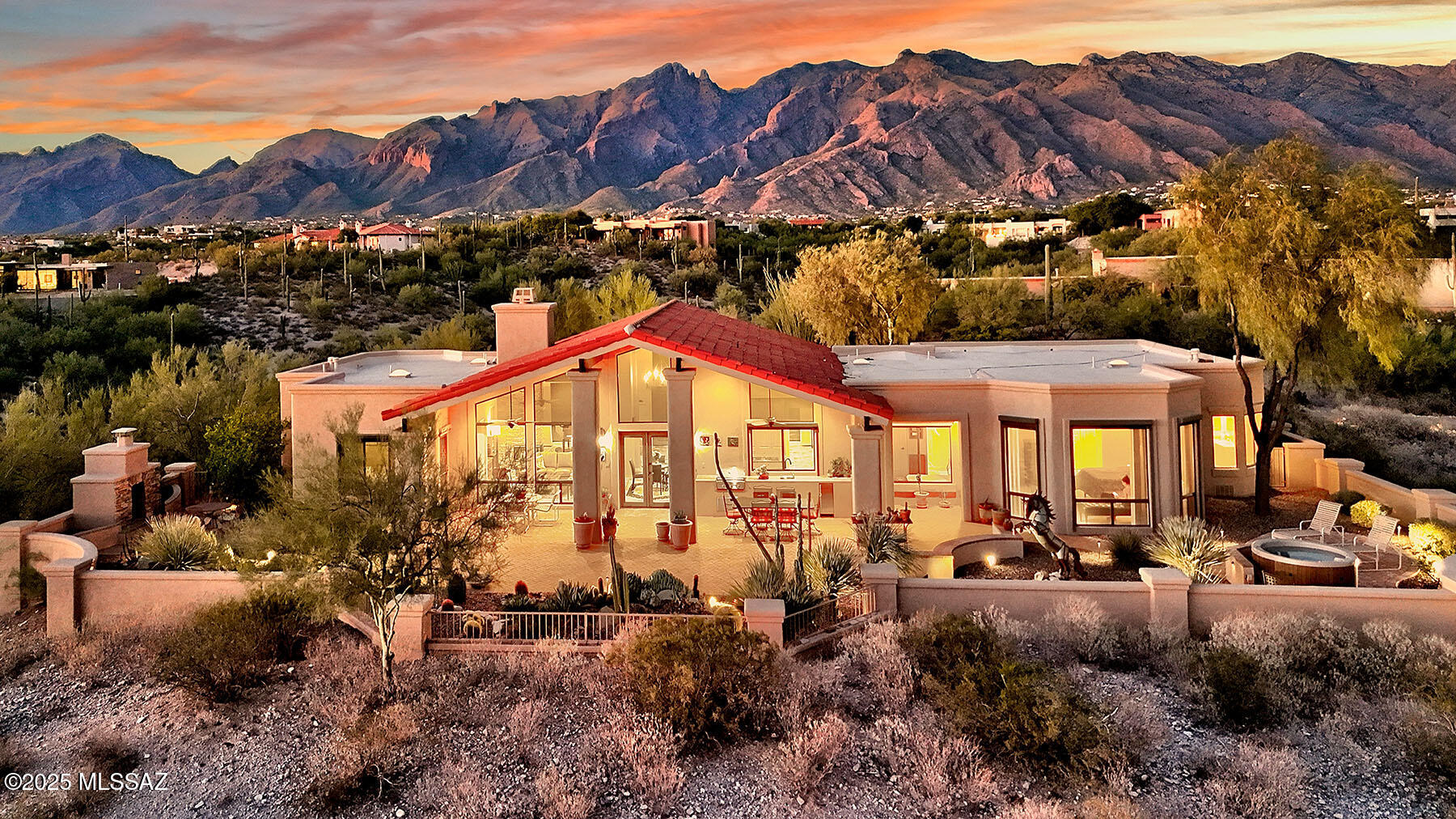 Located in the highly sought-after guard-gated Catalina Foothills Estates #10, this exquisite custom home sits at the end of a private cul-de-sac, offering unmatched privacy, serenity, and dramatic panoramic views of 5 mountain ranges and twinkling city lights. Built by renowned builder Gary Almli, this one-of-a-kind residence is perfectly situated on over 2 acres of lush, natural desert and showcases timeless Southwestern elegance. As you arrive, a new paver driveway leads to a striking entrance and newly installed rustic garage doors. Step inside to discover soaring ceilings, clerestory windows, and an open-concept floor plan that floods the interior with natural light. Rich textures including beamed ceilings and a stacked stone fireplace create warmth and sophistication — all on a single level.The heart of the home is the chef's kitchen, featuring hickory cabinetry, brand-new JennAir appliances, a warming drawer, ice maker, and a large center island. The eat-in kitchen seamlessly opens to the family room, making it ideal for entertaining. The expansive primary suite is a private retreat,  complete with two walk-in closets, a jetted tub with mountain & city views, a tiled shower, and luxurious finishes throughout. The guest wing offers privacy for visitors with two ensuite bedrooms, a wet bar area, and abundant natural light, perfect for multi-generational living or hosting in style. Step outside to your private covered patio, ideal for year-round outdoor living. Enjoy stunning vistas while relaxing
year-round in the new hot tub, grilling on the new built-in BBQ, or sipping a drink from the new U-Line outdoor refrigerator. Cozy up to the outdoor fireplace as you take in the magical desert sunsets. Additional upgrades include: 2 new HVAC units, recent exterior paint, new blinds and 5 remote sun screens. This is an exceptional opportunity to own a truly special home in one of Tucson's most prestigious gated communities. Homes of this caliber, with unparalleled views and thoughtful upgrades, rarely come on the market.
