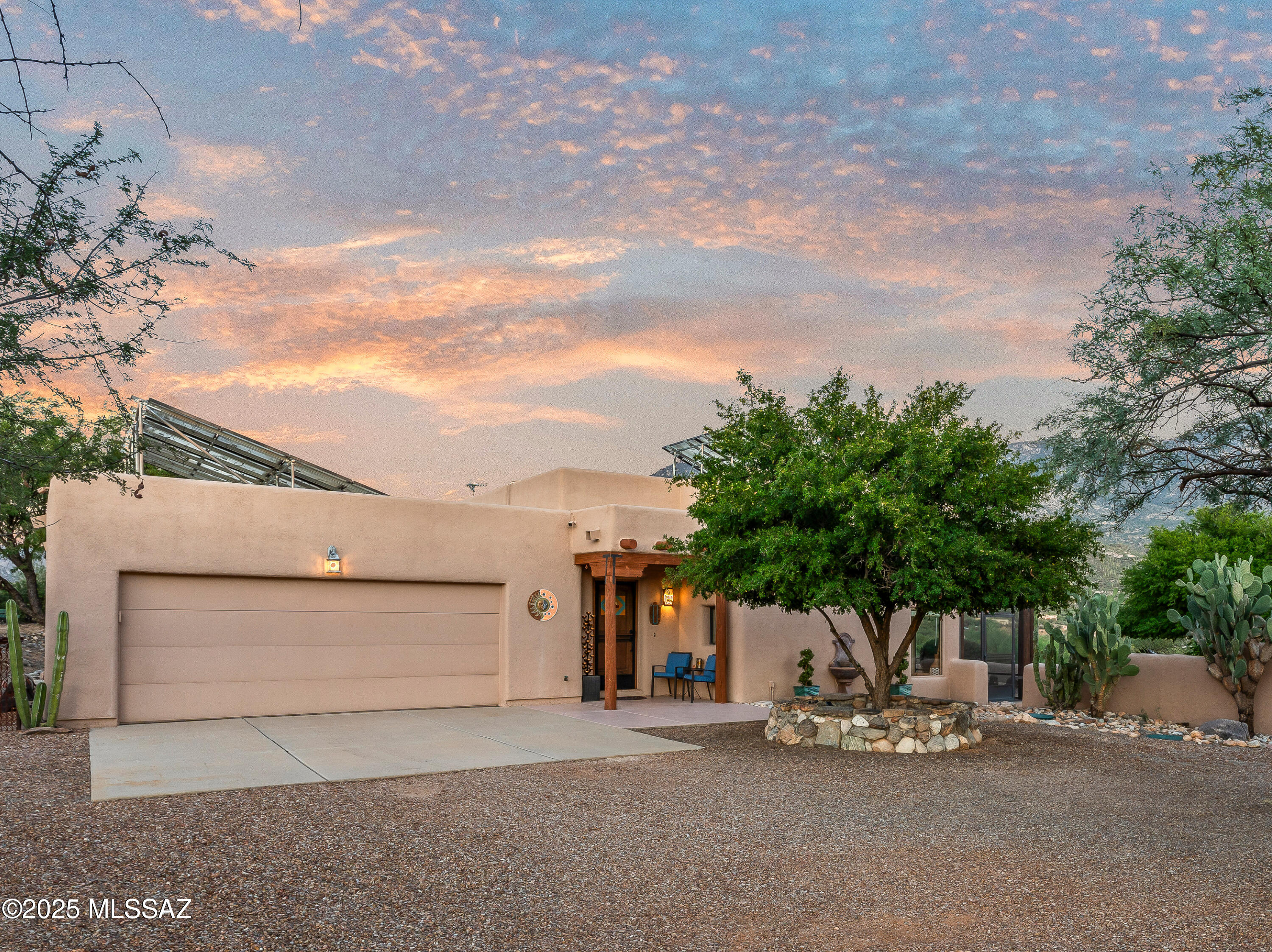 Discover authentic desert living on 4.2 private acres with sweeping Catalina Mountain views. This custom Santa Fe residence embodies warmth and craftsmanship—viga-beam ceilings, rounded arches, skylights, and beehive fireplaces inside and out create an effortless connection to the Sonoran landscape. The kitchen anchors daily life with chiseled-edge granite, an induction cooktop, pullout shelves, and abundant storage. The floor plan provides three bedrooms and two baths, plus a versatile flex room and a dedicated office with convenient garage entry. In the serene primary suite, heated bedroom floors offer year-round comfort, complemented by a walk-in shower and an in-bath washer/dryer. Outdoor living is where this home truly shines. The east-facing backyard invites cooler evenings on a screened patio with fans, a covered ramada for dining or lounging, and flagstone walkways. Practical upgrades includeleased solar, automated irrigation, and a Tuff Shed. The oversized, extra-wide and extra-deep two-car garage features a freshly coated floor, workshop space, and an EV charger. Set on a quiet road and zoned for horses, this property places you moments from Catalina State Park's trail network for hiking and mountain biking, with nearby shopping and dining for everyday convenience. An adjacent 1.5-acre lot is available exclusively to the buyer which isan opportunity to expand your footprint or secure added privacy. Owner/Agent.