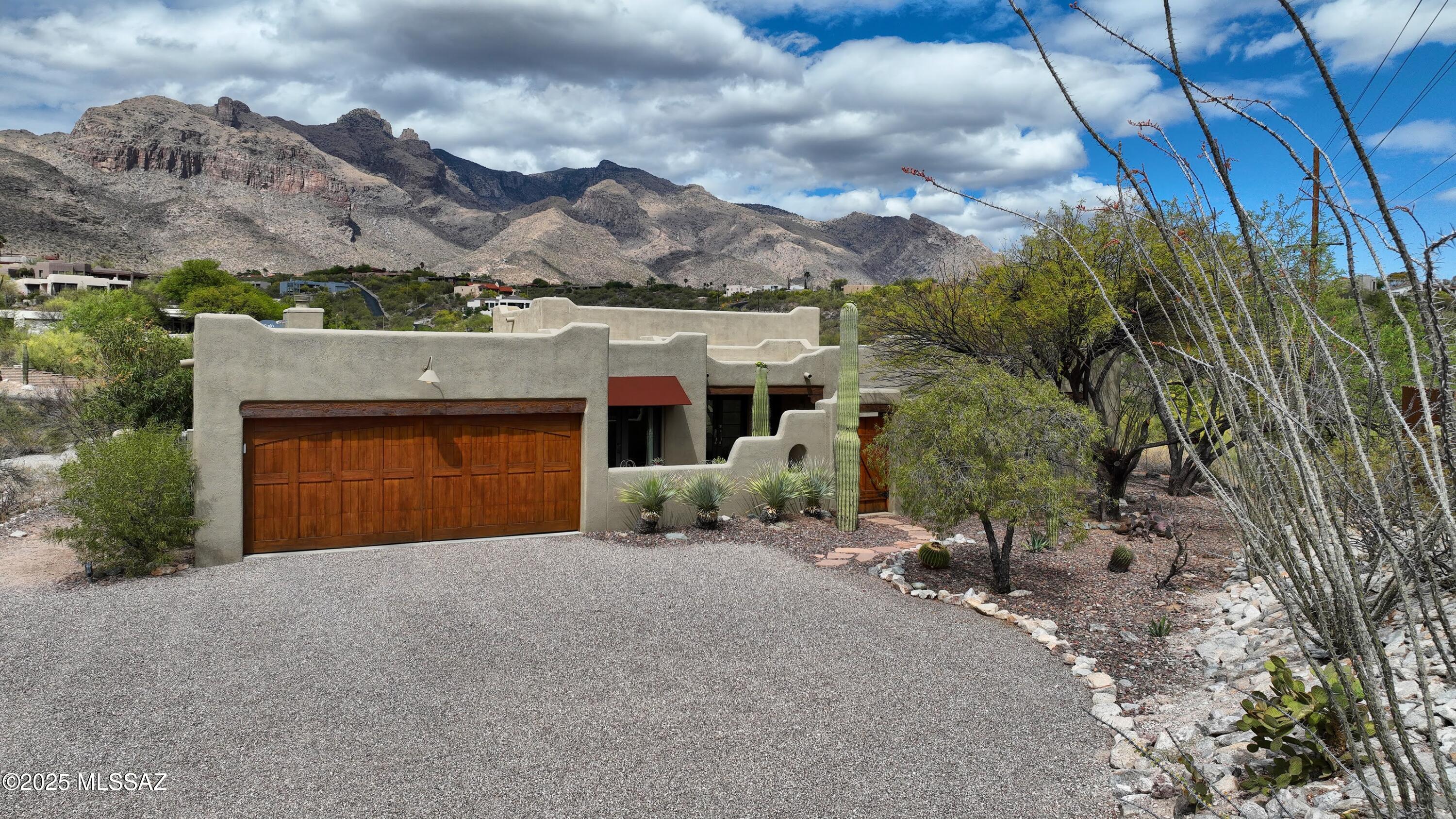 Classic SW style meets timeless elegance in this stunning home w/unobstructed Catalina views inside & out. Welcoming flagstone courtyard w/stately saguaro sets the tone. Inside, sky-high exposed beam ceilings & Saltillo tile floors enhance the authentic charm. Spacious backyard features a sparkling pool, lg cov'd patio & mature landscaping. Kitchen is a dream w/stainless steel appliances, granite counters, clear alder cabinets & lg bkfst nook. Greatroom, currently used as dining area, features a stacked stone FP & banco seating. Living room impresses w/clerestory windows, French doors & amazing views. Spacious primary offers bay window, dual sinks,  lovely walk-in shower & more views. 3 addl bedrooms full guest bath & 2car gar w/storage complete the picture. A truly special desert retreat
