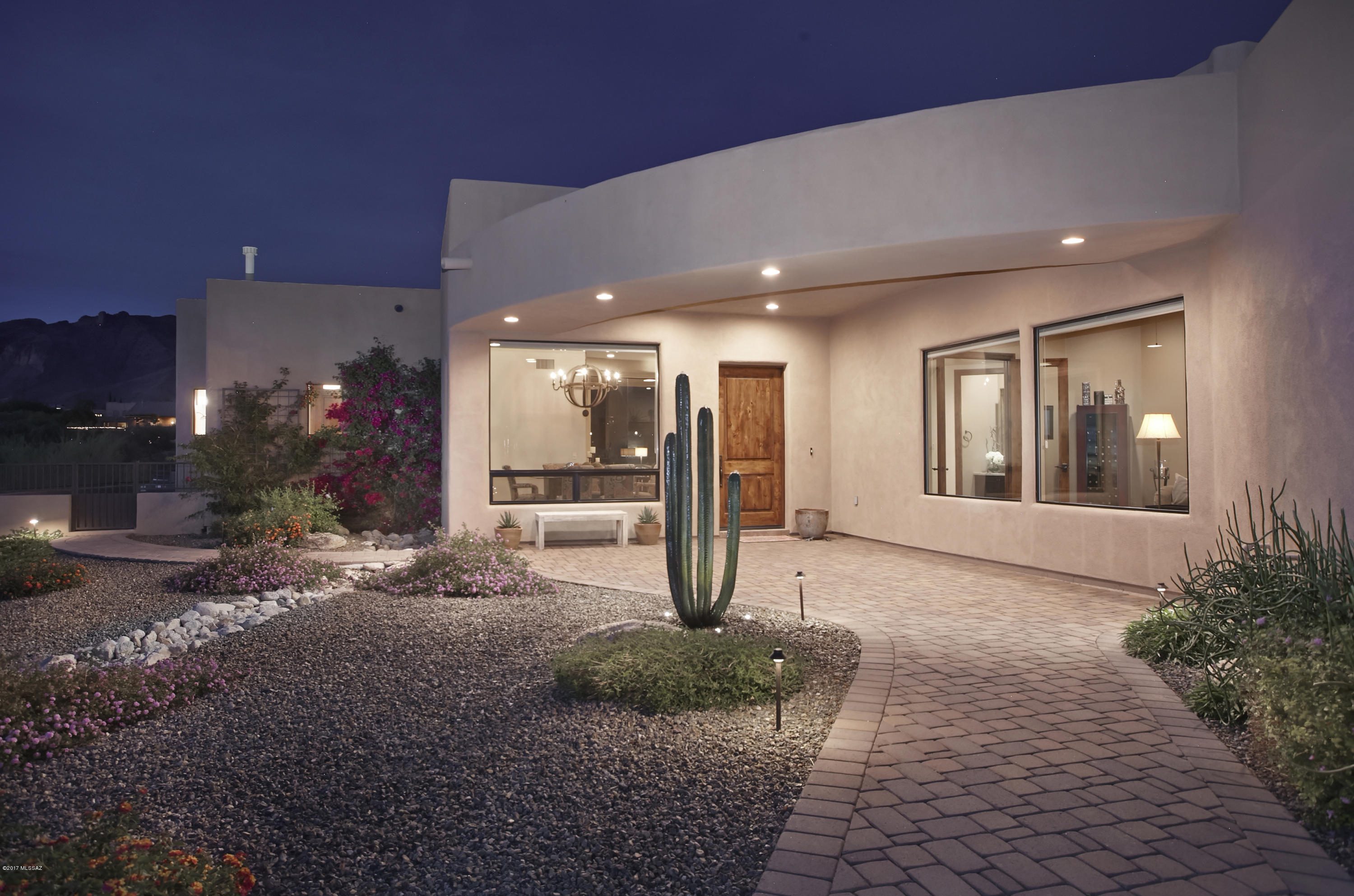 Contemporary home with Breathtaking Unobstructed Sweeping Catalina Mountain Views. The Great Room with 14' ceilings showcases the 10' seamless windows framing the Catalina Mountains. The Master Bedroom also boasts fabulous Mountain Views. The Master Bath incorporates a walk-in shower and soaking tub. Tile throughout with custom wood floors in the Master Bedroom and Den. Alder Cabinets in the eat-in kitchen complement the granite counters and stainless steel appliances. Alder doors and trim throughout. The brick paved driveway and rear patio are just some of the custom touches you will see in this very special home.