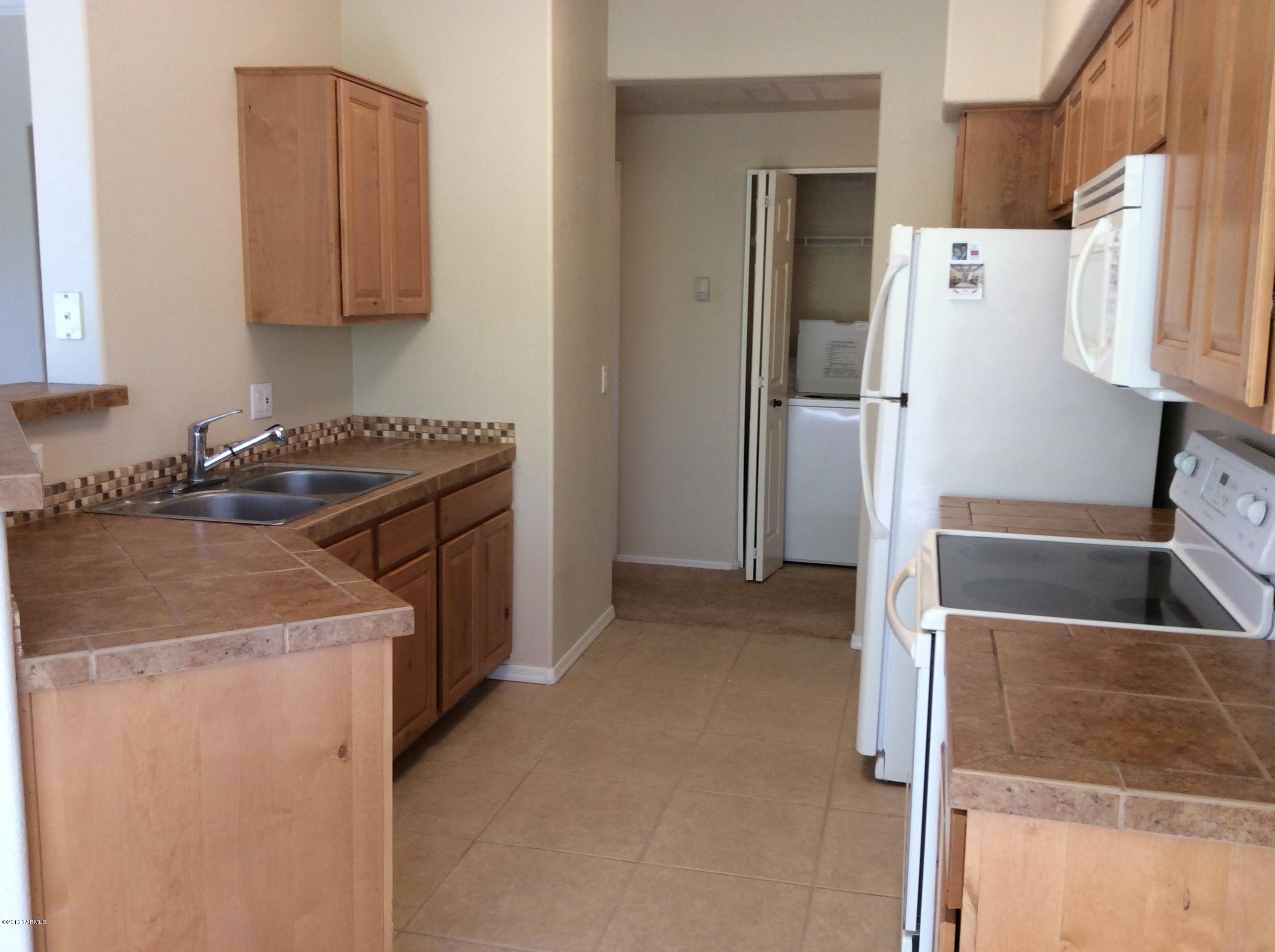 Gorgeous 2 bedroom 2 bath condo located in wonderful gated community at Pinnacle Canyon. Tile in kitchen and bathrooms, large living area open to kitchen with tile countertops. Dining area with access to covered patio.  Master bedroom has walk-in closet. 2nd bedroom has his and her closets.  Two full bathrooms with tub/showers.  This home faces interior courtyard with nice green grass views.  Resort style amenitites - heated pool and spa, exercise room, clubroom and so much more.  This home also comes with a 1 car garage.
