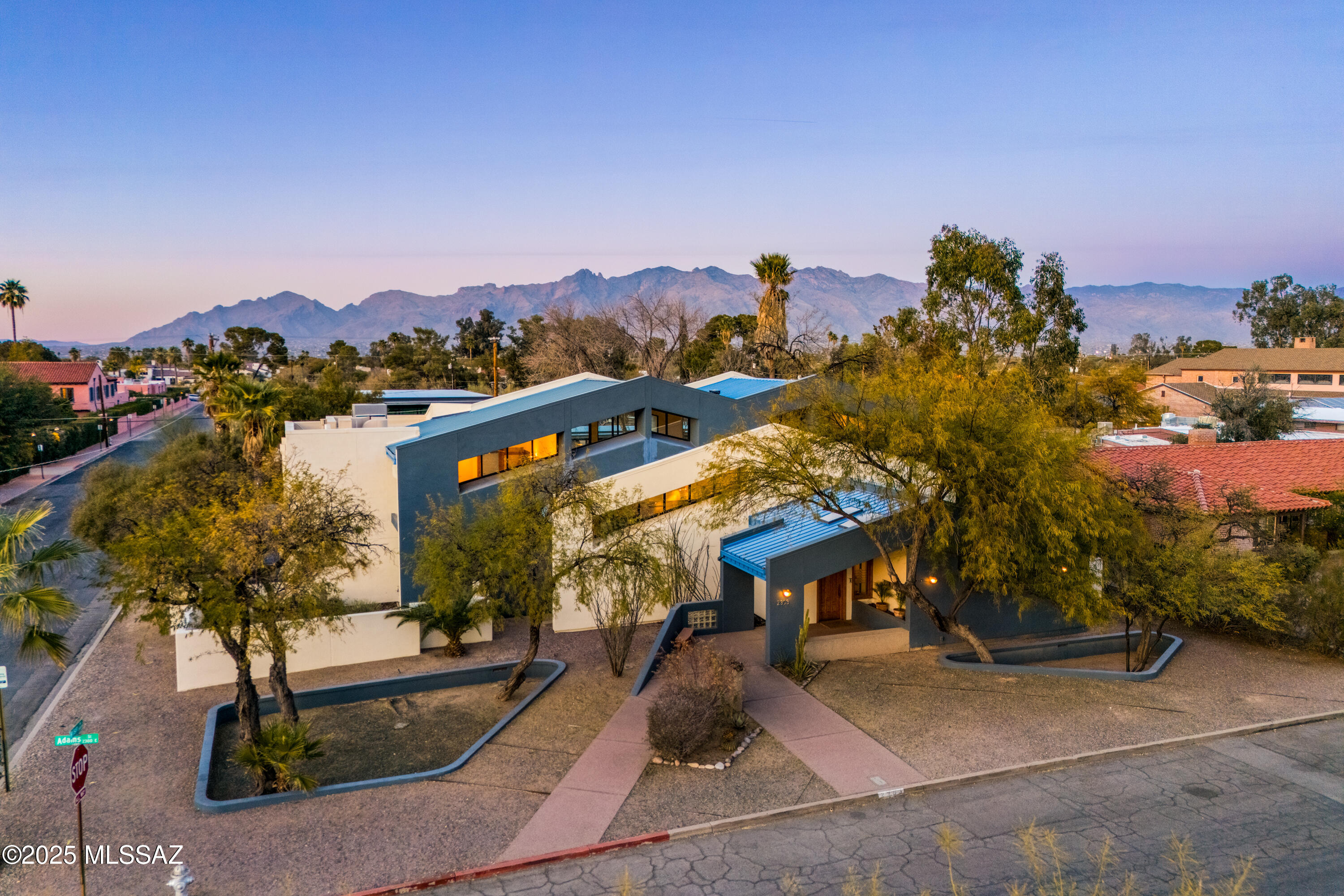 Nestled just a block from the historic Arizona Inn, this architect-designed contemporary home is a haven for admirers of mid-century and post-modern design. Situated on a generous corner lot, the property combines exceptional privacy with striking architectural features, including high clerestory windows that flood the interiors with natural light. The great room is a showstopper, featuring dramatic two-story, north-facing windows that offer panoramic views of the lush yard, lap pool, spa, and the majestic Catalina Mountains. Upstairs, the primary suite is a tranquil retreat, complete with a private balcony, a luxurious double shower, and an oversized walk-in closet.  The first downstairs guest bedroom features a new ensuite bathroom, while the second guest bedroom has access to the updated hall bathroom, enhancing privacy and convenience.  Designed for versatility, the home includes a library that can easily serve as a fourth bedroom and a bonus room off the three-car garage--perfect for a home office, gym, or hobby space (not included in the square footage). The chef's kitchen is thoughtfully designed, boasting a central island, walk-in pantry, appliance garages for clutter-free countertops, a Sub-Zero refrigerator, and a high-end stove. Whether hosting grand gatherings or enjoying quiet solitude, this home seamlessly blends elegance with functionality. Recent updates, including new A/C units and one new water heater, ensure modern comfort and efficiency. Don't miss this unique opportunity to make this dream home yours!
