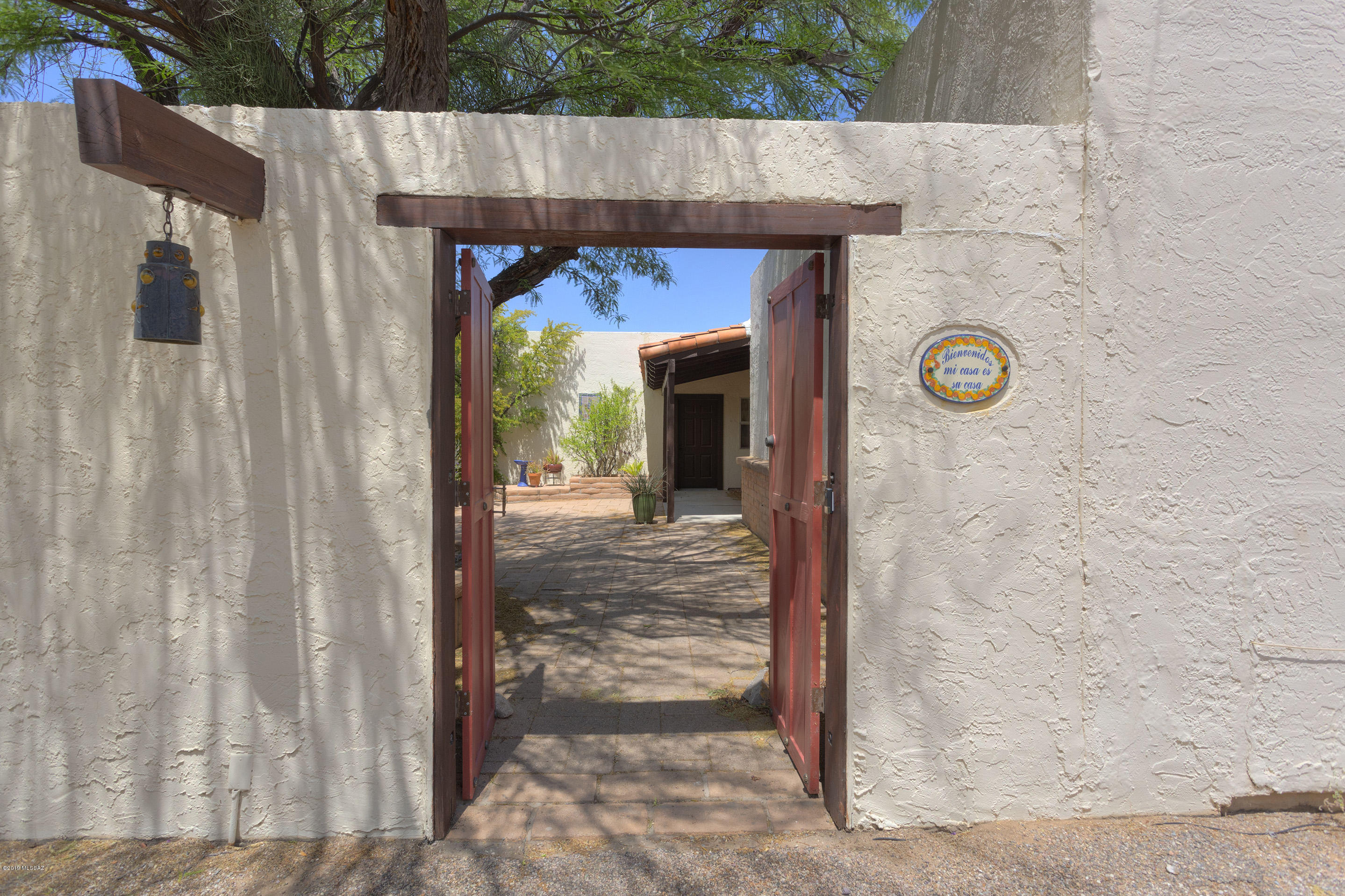 Very private custom home set far back on 1.01 acres surrounded by mesquite trees in a picturesque, quiet setting complete with views of the Santa Rita Mountains. This spacious home with 2,461 sq. ft. has 3 bedrooms/2 baths in the main house with an attached casita/studio with bath that could be used as a bedroom, office, art studio, workshop or whatever! It opens up to the back courtyard and deck and even has a private 12x24 slab that you could use as extended outdoor space. The entry to the home is through the large wooden door that takes you to a private courtyard and offers lots of possibilities for a fountain, garden or dining area. The gorgeous 20'' porcelain tile throughout the home is most impressive as is the light and bright large great room with a beehive, wood burning fireplace. Views span the length of the living area with patio doors that take you outside to an enclosed are and raised deck where you can watch the stars and the sunsets under the covered ramada. You'll want to make this your own oasis in the desert and you'll have all the basics you need with big rooms, textured ceilings, stainless appliances, washer and dryer, an 80 gallon solar/electric water heater. This home is in a non-age-restricted area of GV with no HOA. And, yes, you can park your RV!