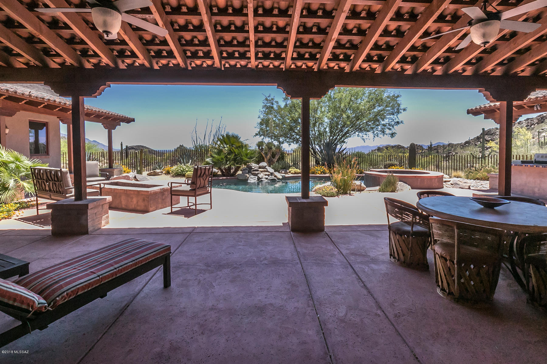 Beautifully designed Territorial style home with burnt adobe accents and barrel tile porch roofs situated in the lower area of Canyon Pass. This amazing home has no interior steps and is sited to take advantage of outstanding views of the Tortolita Mountains on three sides and the Tucson valley to the south which provides the perfect platform to view the shimmering city lights, summer monsoons and Tucson’s world famous summer lightning shows. Enjoy everything prestigious Canyon Pass has to offer without the inconvenience of the long drive up the main canyon road. The interior offers an open floor plan with over-sized gourmet kitchen, tumbled travertine flooring, alder cabinets, butler’s pantry, climate-controlled wine closet, soaring beamed ceilings and a very private guest casita.