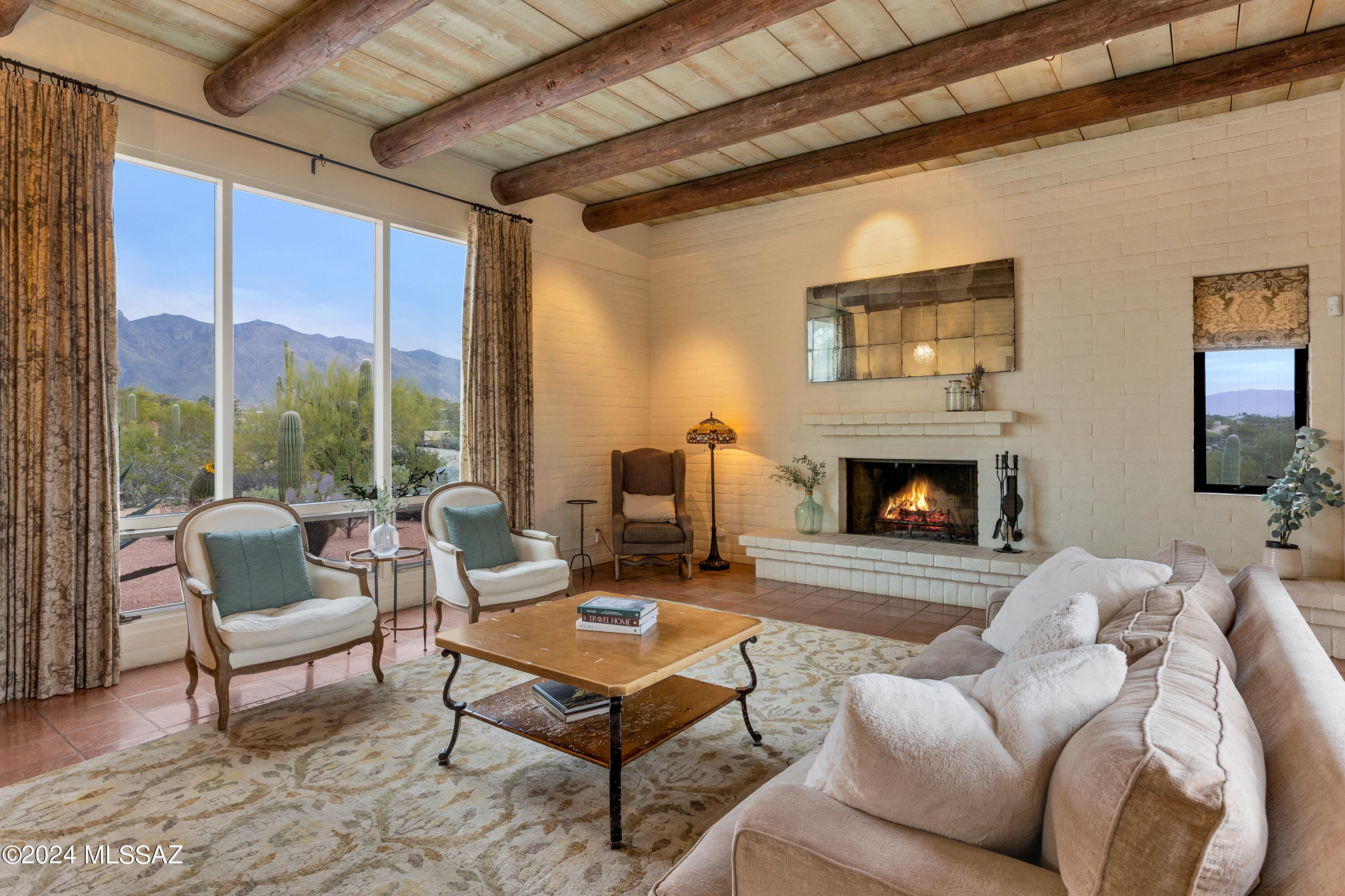 Gorgeous Views! A vine-covered trellis draws you in & leads you to the entry of this very special desert home in the coveted Catalina Foothills Estates No 7. With four bedrooms & three bathrooms spread across almost an acre of land, this home offers both space & tranquility framed by walls of windows to
take in both the mountains & city lights. With Tucson's finest restaurants & shopping destinations just minutes away, you truly have everything at your fingertips.
Step inside and be enveloped by the rustic elegance of high beamed ceilings and custom, locally sourced
concrete tile floors. The owner's suite & its sumptuous bath -- complete with his/hers vanities & closets, steam shower, & soaking tub -- overlook the backyard pool with their own private patio, creating a cozy retreat to unwind in after a long day. 
A spacious guest suite plus two additional bedrooms sharing a convenient jack-and-jill bathroom ensure everyone has their own space.
The kitchen is a culinary haven, featuring a Viking dual fuel double oven range & 2 brand new sub-zero refrigerators, imported French tile, a prep sink & concrete & butcher block countertops with apron sink, offering both functionality & style coupled with a plethora of custom cabinetry in both the kitchen & connected family room.
Blend indoor/outdoor living & entertaining seamlessly with oversized glass sliders throughout the
home as well as a pass-through entertaining window in the kitchen. Outside, the yard beckons with its lush landscaping and multiple patio areas perfect for soaking in the sun or hosting al fresco gatherings. Relax poolside or fire up the new BBQ grill -- an ideal setting for year-round enjoyment.