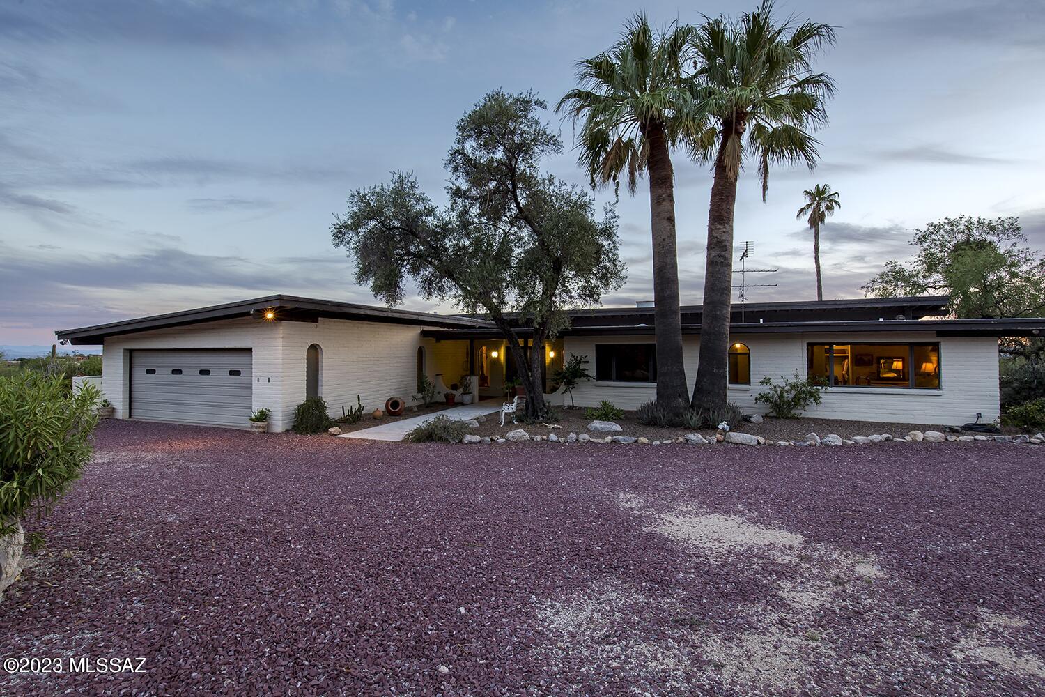 With only 2 owners, this David Fraker architectural home was built in 1970 and is located in the coveted gated Skyline Country Club Estates. The home sits on an elevated lot providing a panoramic view of Tucson's mountain ranges and the Coronado National Forest. The long private drive leads you away from the main road to your home. The foyer's grand entrance invites you in through the wooden double doors.  The large living room with exposed wooden beams, high ceilings and wood burning fireplace offer sensational city views. Off the large kitchen you will find double pantry closets giving much needed space for all your gadgets.  The formal dining room offers space for large family gatherings, overlooks the Olympic size-like pool and natural desert.  The two separate patios, allow you to welcome each day with a cup of coffee and watch the sunrises on the East and unwind and relax while you watch the sunsets on the South.  The laundry room and garage are both spacious and offer plenty of storage space. In the Primary bedroom, the large double doors invite you to the outdoor patio, the ensuite has a gorgeous walk-in shower and jetted tub while the walk-in closet provides ample space and storage. A guest suite with full bath and private entrance is separated by the laundry room to the main house. The other 2 bedrooms offer ample space with good-sized closets. The guest bathroom is the perfect size for guests. The privacy, views, location and space are exceptional, now add your style and touch to make it your own. Please see mattorport for additional insight of this magnificent property.