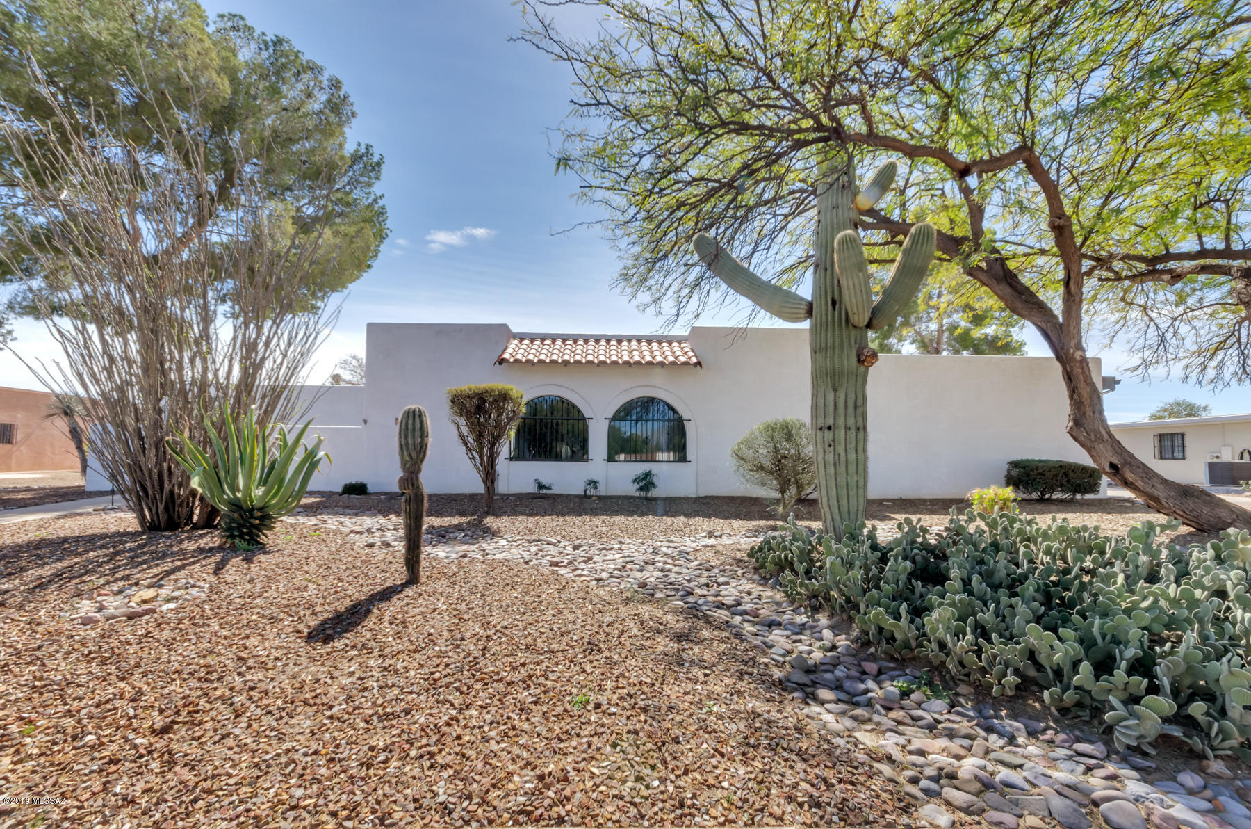 One of the largest free standing homes in the desirable Dorado Country Club Estates is located on a beautiful .39 acre lot w/pine, mesquite & citrus trees. The formal living room & dining room look NE at the mountains in this well maintained 2.656 sf home w/newer HVAC, roof, & water heater: new porcelain tiles in the master & guest bath, & new wood laminate floors in the larger master BR & walk-in closet. Enjoy the enclosed brick & turf grass courtyard from the sunny, glassed in Arizona room. This heated & cooled extension of the kitchen/family room gives you vista of green trees & blue skies. An approximate 300 sf air conditioned outbuilding used as boat storage could be your craft room, studio, shop or man cave. Parking for 6 cars on the cement & brick paver side driveway! Owner/Agent.