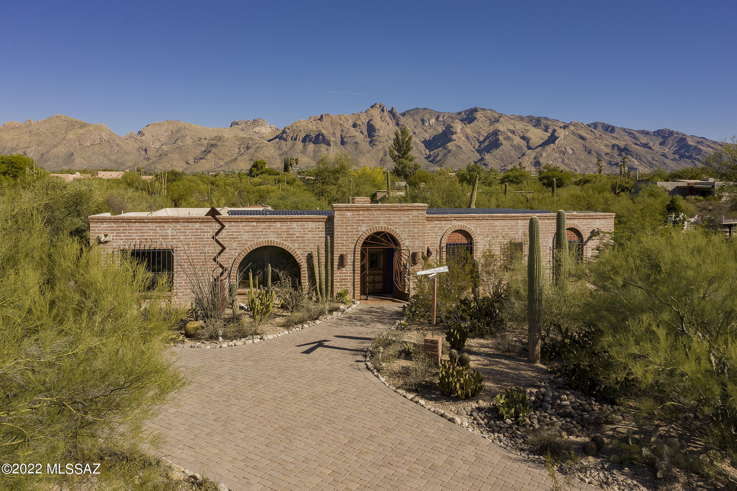VERY CHARMING 3 bedroom (plus studio/workshop) burnt adobe in the heart of Catalina Foothills Estates #7! GORGEOUS wood beams, warm hexagonal saltillo tile floors & special adobe beehive fireplace. Large elevated corner, cul-de-sac lot w/ long paver driveway & perfect north/south orientation! Updated wood sliding doors lead to wonderful covered brick patio overlooking large sparkling pool & very low maintenance backyard. Many unique details & AUTHENTIC architectural features: lovely stained glass windows, exposed adobe walls, detailed wrought iron doors, built-in wet bar & bookshelves, numerous arches & skylights.  Prepaid solar lease. This one owner home is INCREDIBLY PRIVATE, has GREAT VIEWS & has been lovingly maintained. MOST DESIRABLE neighborhood & location! A HOUSE WITH A SOUL!