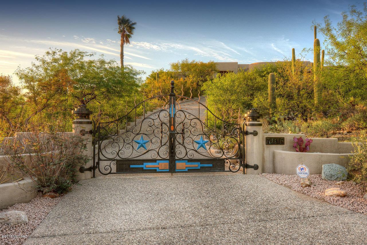 Beautiful Southwestern Contemporary home on a spectacular 5.5 acres in prestigious, gated Redington Ranch! The perfect family home or vacation retreat with magnificent views of the Tucson city lights and surrounding mountain ranges. A view corridor beyond compare!  Generous covered patio overlooking sparkling pool, spa, fireplace and BBQ. A breathtaking setting to watch dramatic Arizona sunsets or gaze at the soaring birds and natural beauty of the desert. Updated kitchen with quartz countertops and new SS appliances. Thoughtfully designed, incorporating several outdoor living areas, including private patio space for each bedroom. Oversized 3 car garage with extra storage and workbench. Community amenities include private horse stables, pool, clubhouse, tennis courts and a private lake. Redington Ranch is a gated luxury subdivision on the far Northeast corner of Tucson, right up against the mountains, offering serenity, privacy, large lots and incredible views. A popular horse community, it has access to thousands of acres of riding and hiking trails in nearby Coronado National Forest. Only 10 minutes from shopping and dining.