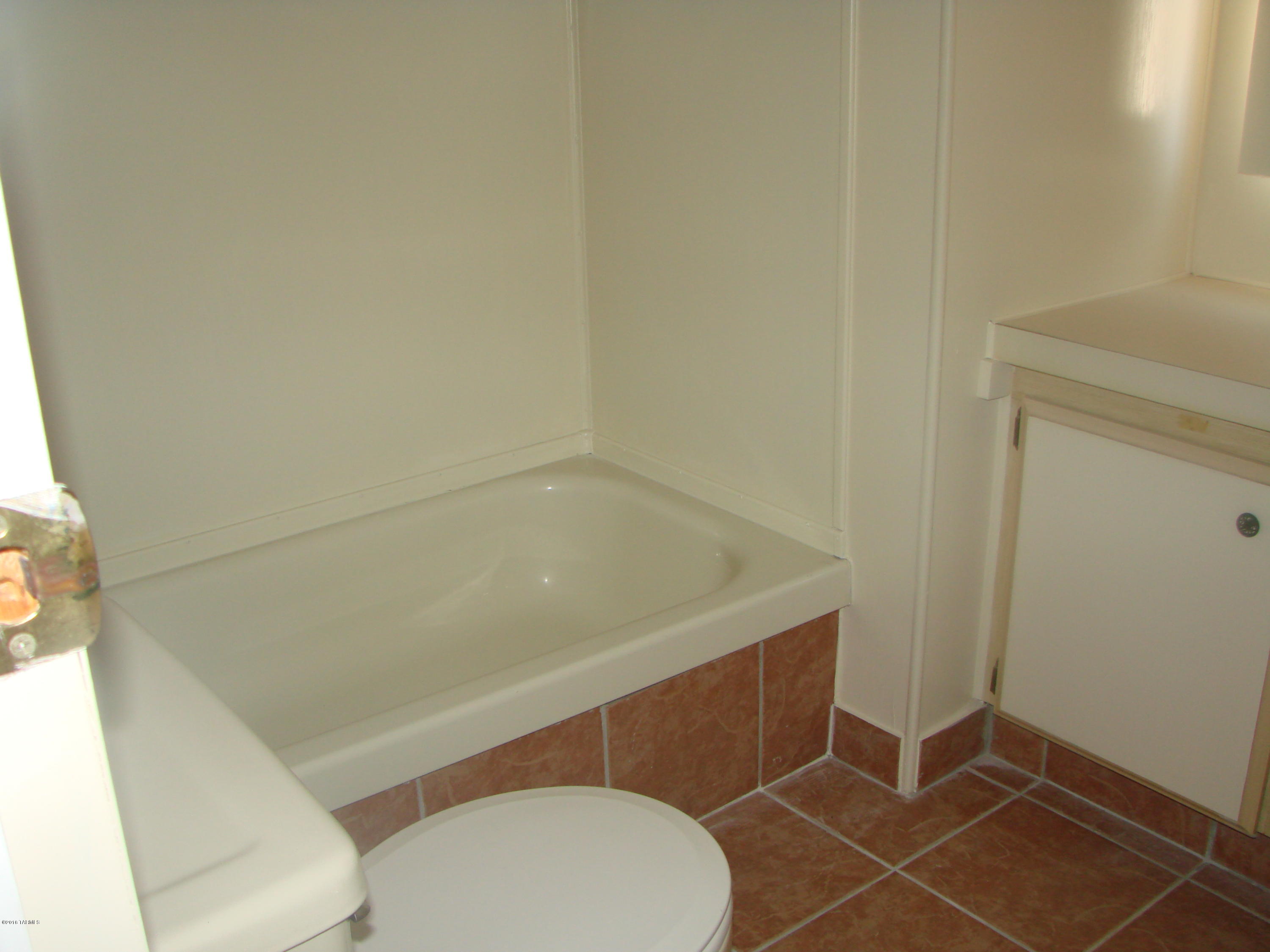 Very nice, remodeled, clean, move in ready  home. New floating wood laminate and tile in kitchen, bath, hall, and living room (great room). New A.C. Newly redone roof. Large covered porch on East side could  easily be made into an Arizona room.  Covered deck on West side.  2 storage sheds and chain linked back yard and sides. Owner will carry with $5000 down, $400 a month for 10 years, and you would own your own home!