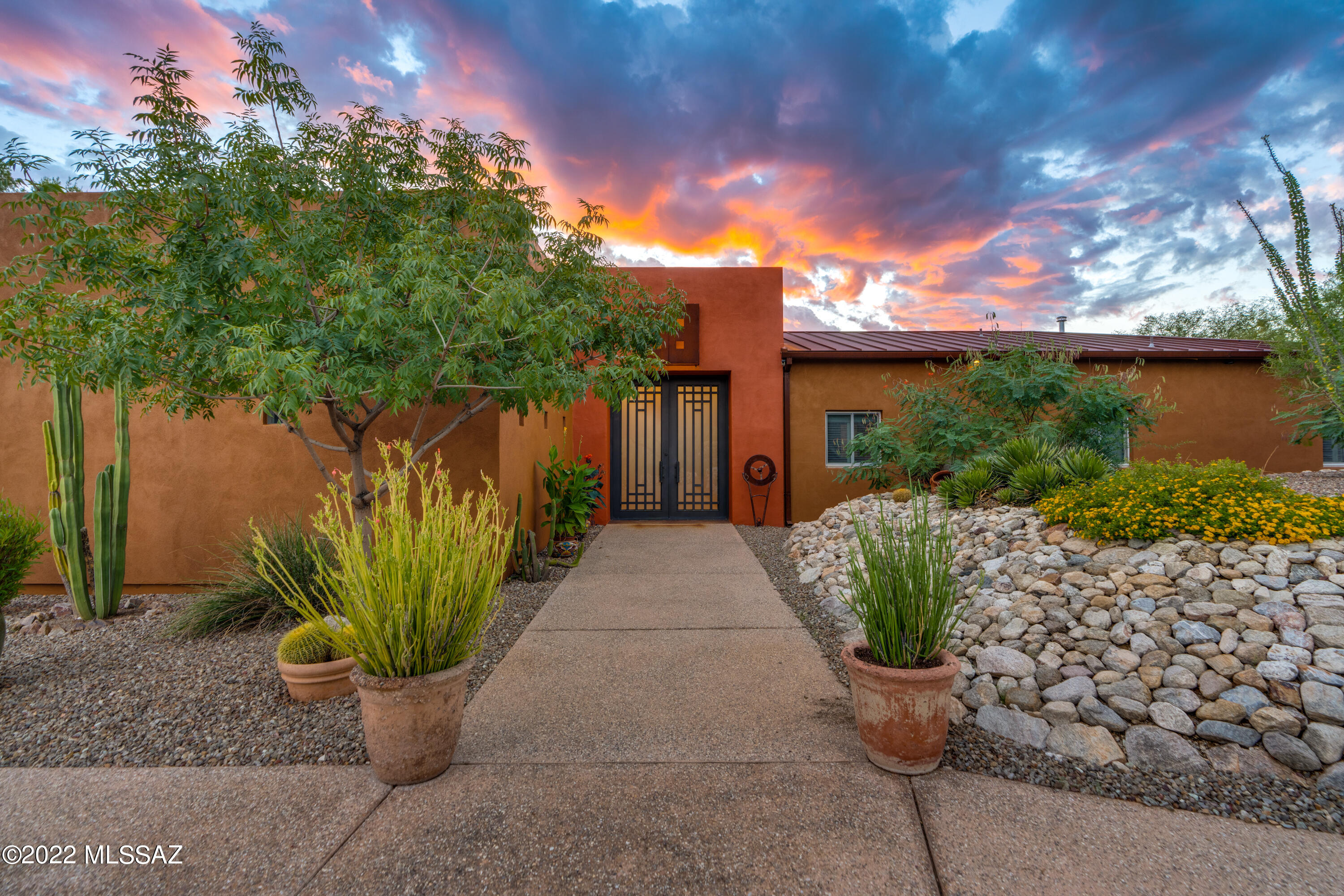 Imagine a stunning,private contemporary home, built by an artist,painted with a brush full of vibrant hues. Welcome to Casa Solar. This beautifully designed modern hacienda style beckons you with a custom steel and glass door,inviting you to the inner grand courtyard. 5 BR,3 1/2 baths nestled on .82 acres.  A wrap-around patio surrounds the interior Courtyard that boasts a solar heated lap pool, additional outdoor kitchen & gas fireplace with numerous seating & dining areas creating an entertainer's dream.Home features stained concrete floors with no stairs, cathedral ceilings with recessed lighting,large picture windows & numerous sliding glass doors to the courtyard.The massive greatroom boasts numerous seating areas with sight line to the huge chef's kitchen. Custom cabinets,white marble countertops and huge island seating six to watch the chef create. Massive great room with split floor plan with Primary bedroom on the west corner. Spacious W/I closet and en suite with double sinks and marble shower. Across the courtyard are 4 additional guestroom and 2 bathrooms. Please see full list of amenities in the Documents tab.Tucson Association of Realtors Home Tour WINNER!