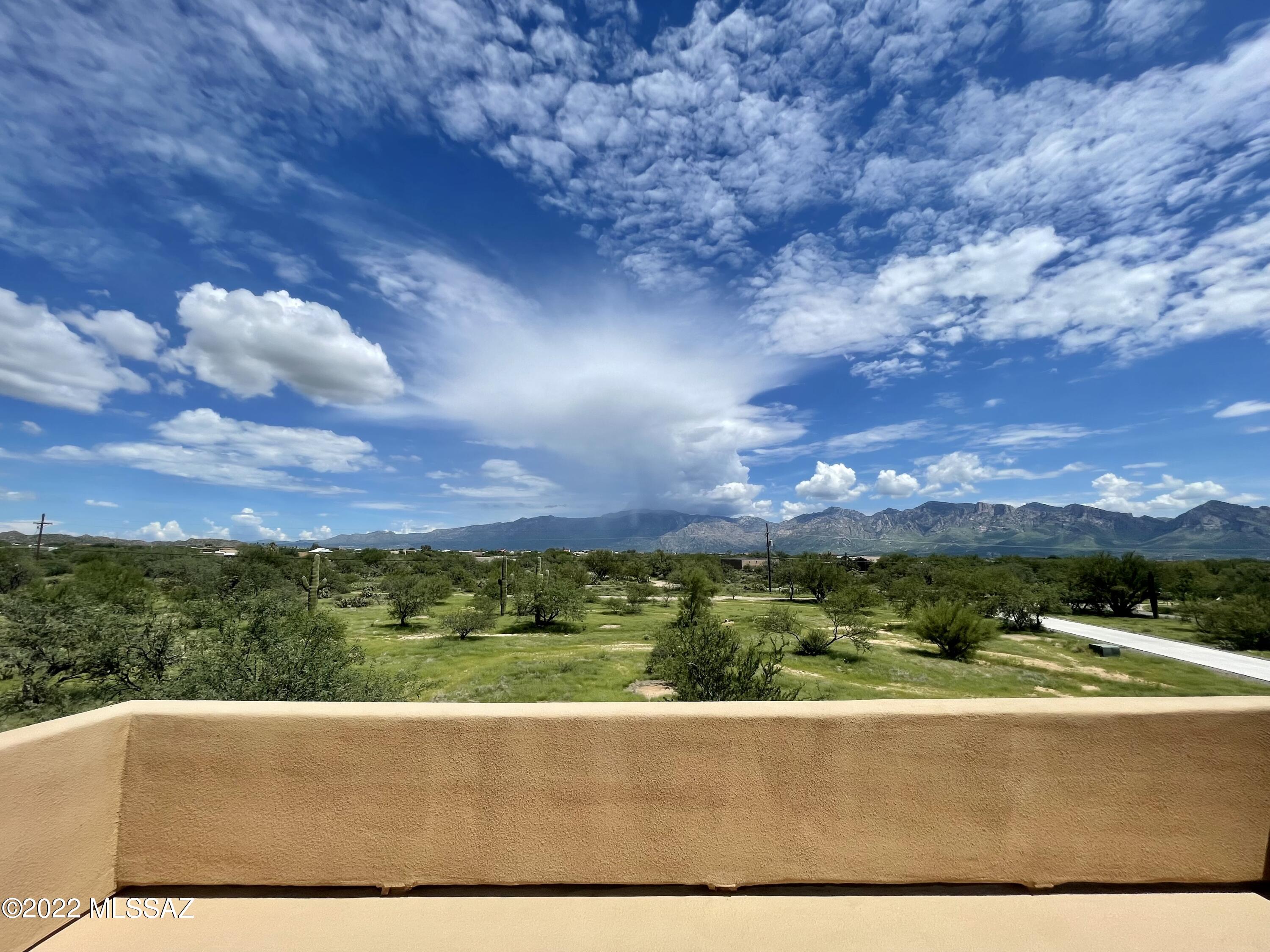 Seller offers $15,000 concessions in lieu of carpet replacement/new flooring. What an amazing difference new floors will make! 2017 Custom built 5,179 sqft home (2 primary suites, 1 downstairs 1 upstairs,) with panoramic views from over 4 acres with a 5,000 sqft steel-frame utility building. Horse property with a strong connection to the Sonoran desert and the surrounding mountains, on a gated private road with only 7 other homes, bordering Oro Valley. With an 850 feet deep Water well, 2 septic tanks -all you need is solar to ''Go off grid''! NO HOA!   This property is a paradise for car collectors/ contractors/ builders/ RV owners or anyone in need of a workshop/storage of a 5,000 square feet ancillary building. It has 2 wide stance car lifts and 2 RV hookups, bathroom, its own septic,400 AMP panel and so much more.  This Energy certified home custom built by owner/builder less than 5 years ago with pride of ownership and attention to detail too many to mention here  please see list attached.
Inside the home the unique steel print porcelain tiles create a harmonious, elegant flow around the downstairs living areas. Connected to the great room is the impressive chef's kitchen.  Enjoy modern maple cabinetry with marble design granite slabs, energy star qualified stainless high-end appliances and deep-basin stainless farmhouse sink.  Oversized island is the focus point of the living room.  Two x 6 burner (yes, 12 burners total!) gas ranges set-up with commercial stainless vent hood and granite slab backsplash with glass tile surround.  
The spacious owners' suite downstairs has access to the back patio with a new hot tub to enjoy the sparkling night sky and moon over the Catalina Mountain Range. The walk in closet has a connecting laundry shoot area with 2 wood baskets to make that chore easy, just to mention a few special features this home has.
The luxurious granite stones and maple cabinets and designer touches of the kitchen harmoniously create a flow all around the home with the same finishes used in all of the bathrooms and the huge laundry room.
The additional room that is currently used as an office, was originally designed as a wine room. The spacious loft upstairs offers endless possibilities for a fun game room and family room with breathtaking views of the surrounding mountains. The second primary Suite upstairs has a guest quarter/in law suite potential (hot/cold water piping and drain all set up). There are 2 additional spacious bedrooms  and a full bathroom upstairs, and the loft was designed for the option to easily add a 5th bedroom if needed.
The huge balcony from the loft is where you can enjoy the Tucson city lights sparkling at night, and during the day the Tortolita and Catalina Mountain views provide a beautiful outdoor sitting area to enjoy.
Seller offers $15,000 concessions in lieu of carpet replacement/new flooring.