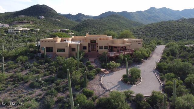 Views Views Views! Breathtaking panoramic views of the Catalinas and city from every room in the front of this sprawling ranch home and astounding views of the Tucson Mountains and pool area right behind you from every room in the rear of the home. This home was built for outdoor leisure living with multiple open air seating options. This home boasts 4/5 bedrooms, 2.5 baths, and attached 3 car garage all on 3.7 acres just 15 minutes from the city in the Tucson Mountains. All exterior windows and doors were replaced in July 2021. Both rooftop HVAC units were replaced in April 2019 and the water heater in 2020. The home promotes natural lighting throughout with a total of 9 skylights. The kitchen features stainless appliances, granite countertops, ample storage and a hidden wine room. The spacious master bedroom features 2 sliding glass doors on opposite ends of the bedroom to facilitate a sweeping viewing experience from front to rear of the home. The remodeled master bath features a walk-in tile shower, stand-alone tub, dual sink granite countertop and custom-made cabinet. A walk-in closet and a pass-through fireplace round out this comfortable and inviting space. The main guest bedroom promotes a sliding glass door with gorgeous views of the pool and mountains that leads out to a sitting area with mounted TV and motorized sun awnings to protect from the western sun. An ensuite bath with granite countertop, walk-in tile shower, and direct ingress/egress to pool area are all highlights of this alluring area for your guests. The smaller room in the front of the house with bookcase and closet could be used as a small office or a 5th bedroom. The family room features an 85 TV and home theater system that stays with the house. This room has pass-through pole beam ceiling and a pecky cypress facing. A dining room and office/den area with sweeping views of the Catalinas rounds out the inside of the home. Horse lovers will appreciate the corral with sun shade and small tack room/shed down below the house.