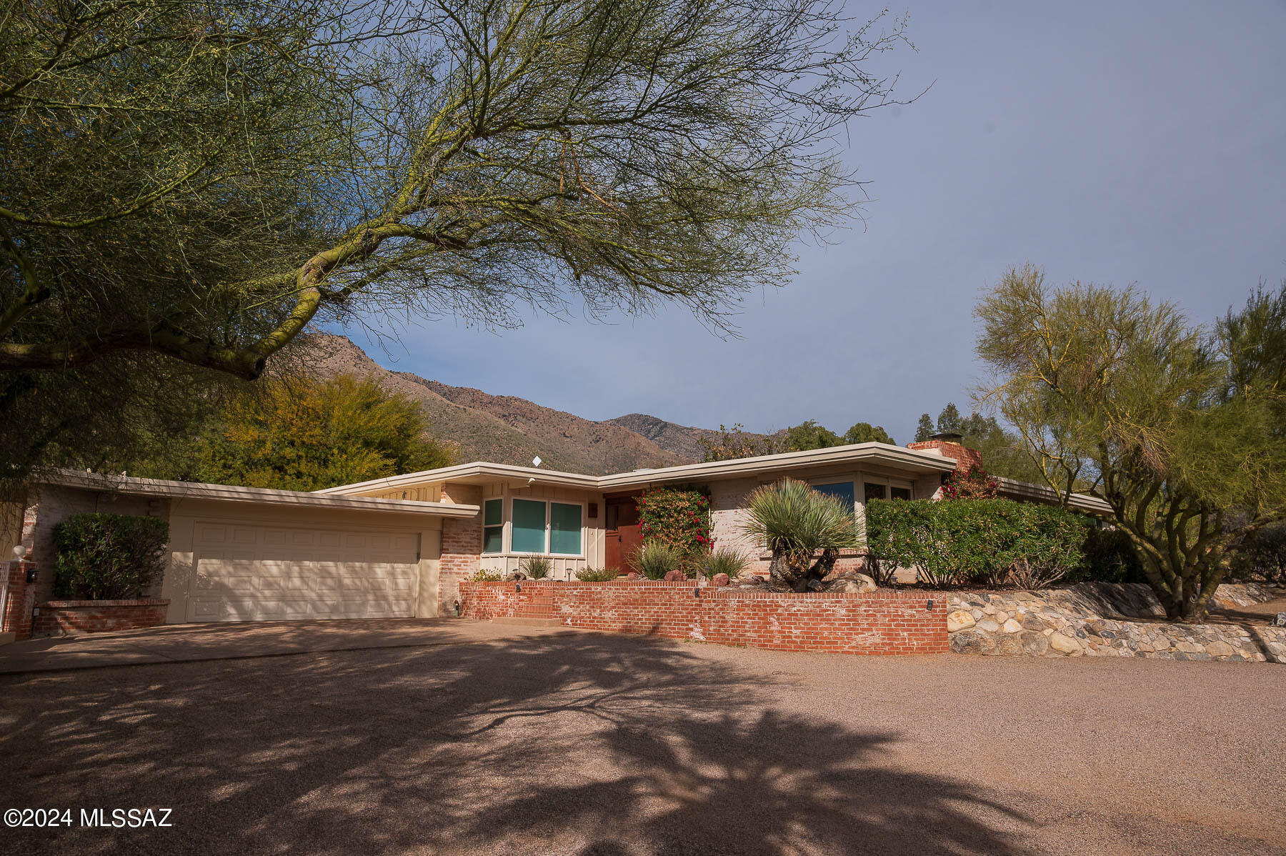 This beautifully remodeled home is a rare find in the established Skyline Country Club neighborhood. This larger home boasts 4 bd/4 ba in the main house plus sitting room/office in master,  and former 5th Bedroom is used as office/storage and has shelves but could easily be converted to a closet.  1bd/1 Guest House and a designated play set area and separated kid safe pool. The sport court will work for many options basketball, pickleball etc...
Enjoy stunning mountain sunsets and city lights from your large covered patio and pool. Full house & guest house remodeled in 2022. Modern kitchen with lots of light opens to large family room. Don't miss the amazing master retreat with a sitting room and newly remodeled bath.