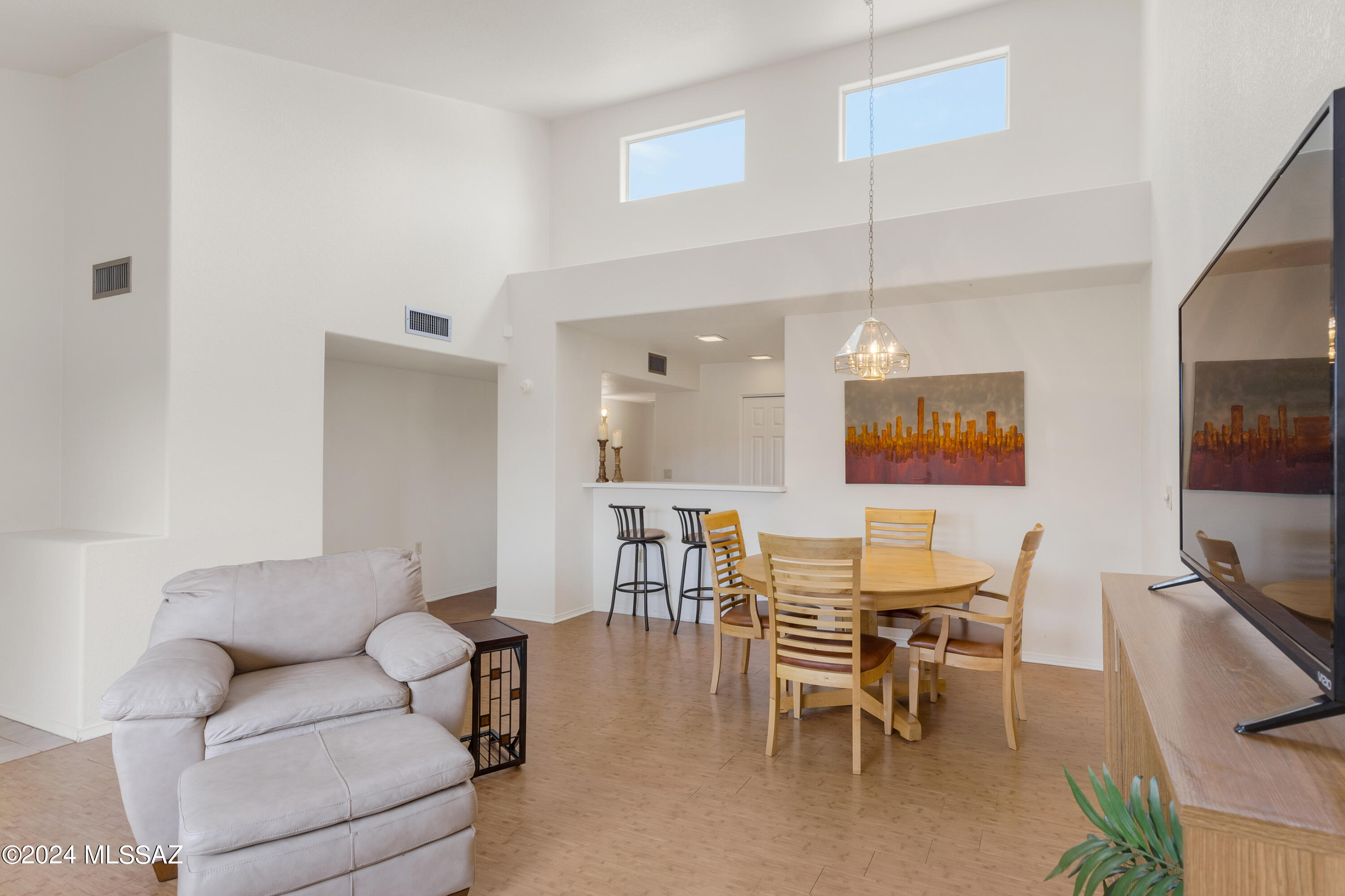 Located in La Cholla Hills, a 55+ active adult community, this spacious end unit 2 br/2bath patio home offers convenience & simplicity. As you enter the home, you are greeted by soaring vaulted ceilings and streaming sunlight. Enjoy a wide galley kitchen open to the living room via a large pass-through.  Yards of counter space, plentiful cabinets & a separate pantry offer ample storage in the kitchen.  The indoor laundry includes stackable washer & dryer.  The primary bedroom has a large walk-in closet & an ensuite bath. The secondary bedroom has double closets with pocket door access to the hall bath. One covered parking space is assigned & plenty of guest parking is available. The extra parking spots out front are a surprise bonus. Rarely are they used by others than by the 2 direct owners. When you bring groceries in it is a real benefit. It is not blocked by covered parking so you see & recognize your neighbors as they stroll by on this quiet street in the morning. The units with covered parking in front don't get this vista. Go outside & sit on the bench to the left & you get a great view of the beautiful sunsets. There is value with a double lot! The HVAC was replaced February 2024 and the roof was replaced in 2019 with some warranty remaining. La Cholla Hills amenities include 2 pools, Jacuzzis, 4 pickle ball / 2 tennis courts, and a clubhouse. Located near the 131-mile Loop for walking and cycling. A sweet retreat indeed!