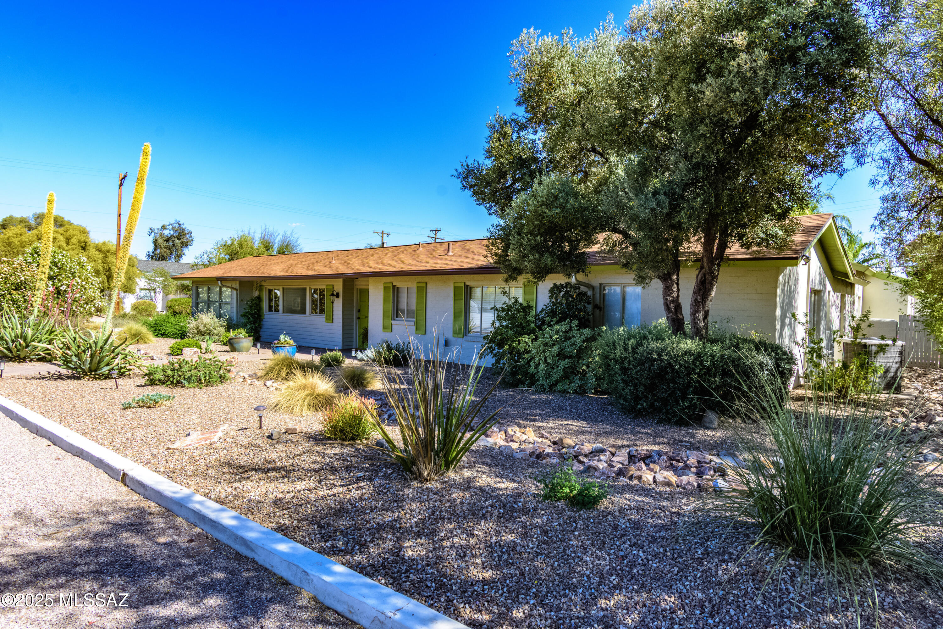 Meticulously maintained by the same owner for 45+ years, this stunning ranch style, mid-town '50's home is a 3BD/2BA + den in Tucson's desirable Historic San Clemente neighborhood blending timeless charm with modern upgrades. Situated on a beautifully landscaped corner lot with a citrus grove, this property features a formal living room with a beehive fireplace, adjacent dining, and a chef's kitchen with breakfast bar, newer stainless appliances, gas range, and warming drawer. A spacious family room includes a built-in dry bar and wine rack—perfect for entertaining. The versatile den/office has a private entrance. Two fully remodeled bathrooms include a luxurious primary suite with dual vanities, walk-in shower, jetted tub, fireplace, and a large walk-in closet...continued.. North/South-facing outdoor areas maximize water efficiency and feature two rear patios ideal for gatherings, with ample space to add a pool. The private garage includes an EV charging station and a large enclosed workshop/storage room. All additions are permitted. Historic status may reduce property taxes by up to 50%. Don't miss this rare opportunity to own a piece of Tucson history with modern comforts in a prime central location.