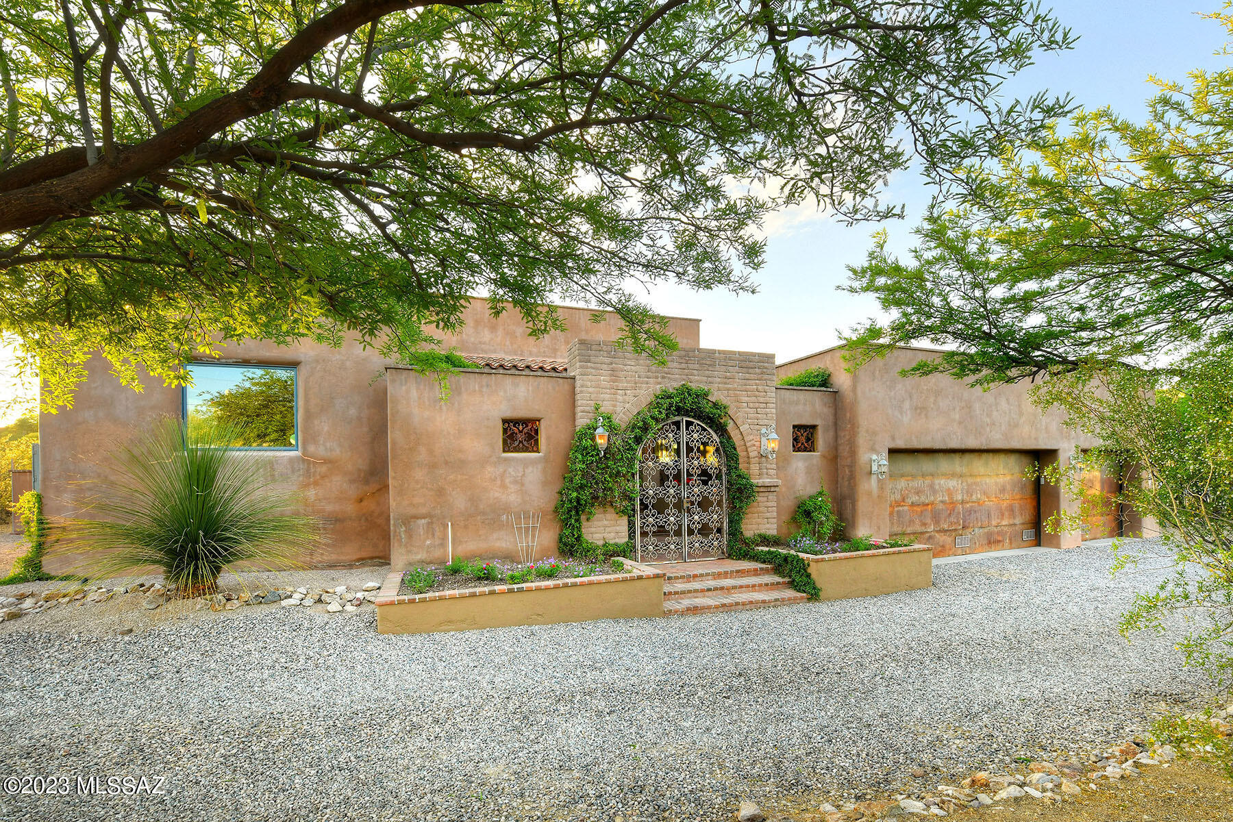 Exquisite newer Arizona Territorial on 2 acres w/ majestic mountain views in Catalina Foothills Estates #2. Charming front gated brick courtyard, living rm & dining rm w/ dramatic 12 ft. high beam ceilings, elegant fireplace, beautiful polished concrete floors, wood cased windows & French doors throughout, gourmet island kitchen w/granite countertops, stainless steel appliances, double ovens, gas stove top, refrigerator, pantry, breakfast area, wet bar w/ wine cooler, large family room, 5 bedrooms (split plan), 3 baths, master w/ sitting area, fireplace, walk in closet, lux bath, natural stone countertops, double sinks, jacuzzi tub, wonderful shower, private entry to rear patio, laundry rm w/sink & 3 car garage. Sensational backyard w/ covered patio, grass, play area & mt views.