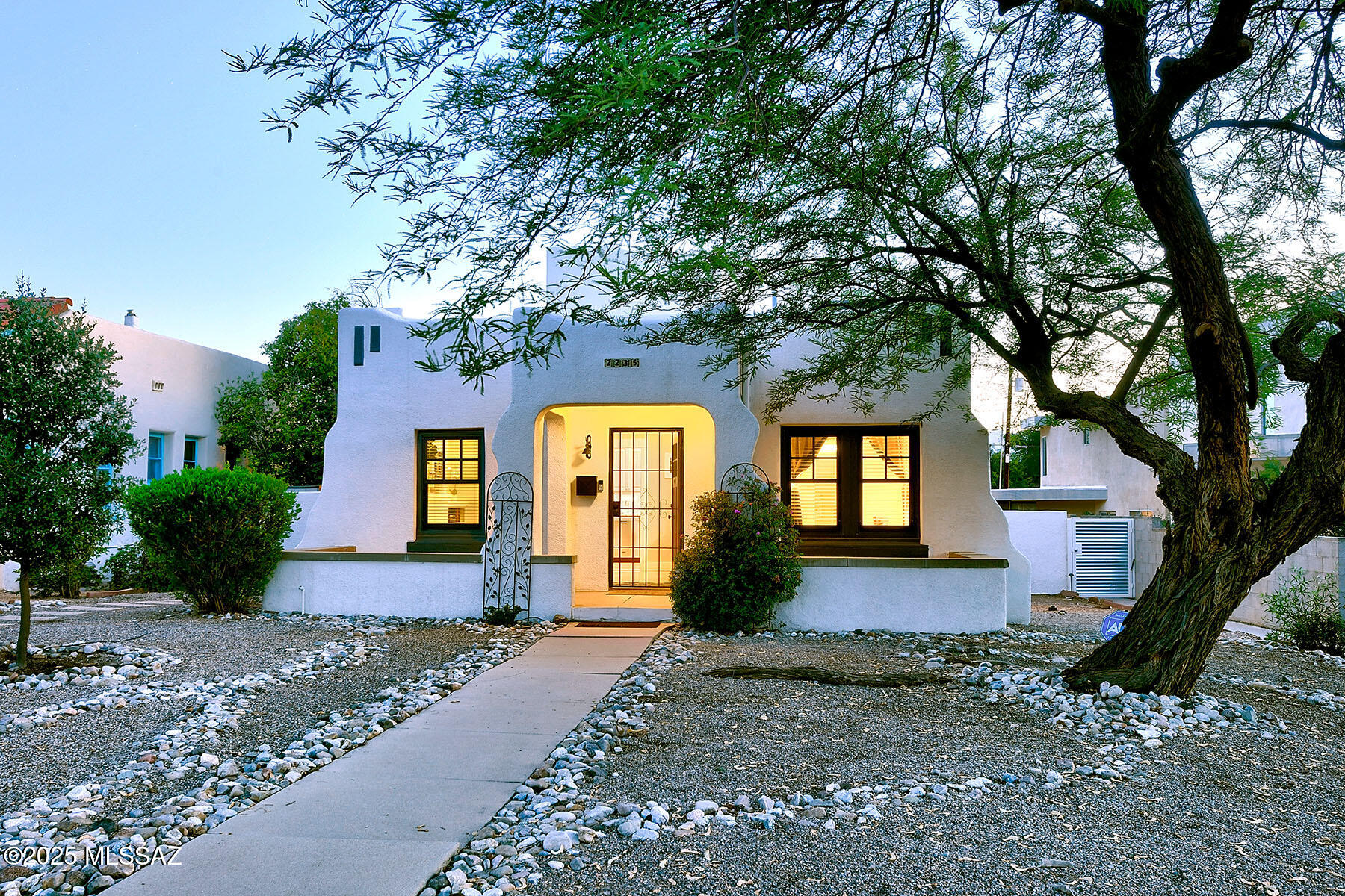 With thoughtful updates and timeless charm, this Sam Hughes treasure offers cozy comfort, character, and convenience. Behind its inviting façade is a wonderful and welcoming main house completed by a detached guest house, a refreshing pool, and energy-saving solar panels. Inside, a light-filled living room with custom built-ins—currently styled as a formal dining area—sets the tone. Two main-level bedrooms are connected by a beautifully remodeled bathroom featuring a subway-tiled shower, mission-style tile flooring, and a contemporary vanity. A separate family room invites relaxation with its gas fireplace, breakfast nook, LVP flooring, and expansive 8-foot sliders that open to the outdoors. 
Upstairs, the private primary suite feels like a retreat, offering an ensuite bath with double vanities, walk-in shower, private water closet, and a generous walk-in closet. From bed, take in views of the Santa Catalina Mountains.
The backyard is a true extension of the living space, with a dramatic wraparound patio featuring wood beams and metal roofing, low-maintenance turf, brick pavers, and a large, fenced-in pool. A detached guest house offers added flexibility for visitors or workspace. Behind the home, a two-car carport over a large concrete pad for 3 with alley provide ample off-street parking.
Beautifully landscaped and full of charm, this home is just steps from the University of Arizona, Himmel Park, and an abundance of local shops, restaurants, and cultural destinations.  This home is a contributing property to the National Historic Register and offers a 35% - 45% discount on property taxes to owner occupants!