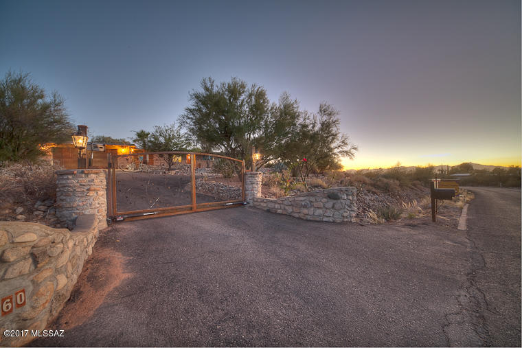 List Range Price: Seller will consider all offers between $439,900-$459,900.  Stunning Burnt Adobe,Casas Adobes Charmer! Nestled in Catalina Foothills. Ornate Custom Solar, Metal Entry Gates welcome you to this beautiful Estate home an Acre of land!Enjoy Catalina views as you nestle in for BBQ, or relax Poolside, or at outdoor gas fire pit. The interior floor plan has been opened up for a cool modern feel using Organic Colors & contemporary finishes, creating wonderful, Expansive space, while keeping true to Period of Architecture. Brand new Kitchen,Granite,Stainless Appliances & new Vanities. New windows, tile, Laminate wood, paint & fixtures all tastefully done.Picture windows bring in the beauty of mountains to your doorstep. Raised,gated Pool, Walking trails, Oversized 2-Car Garage