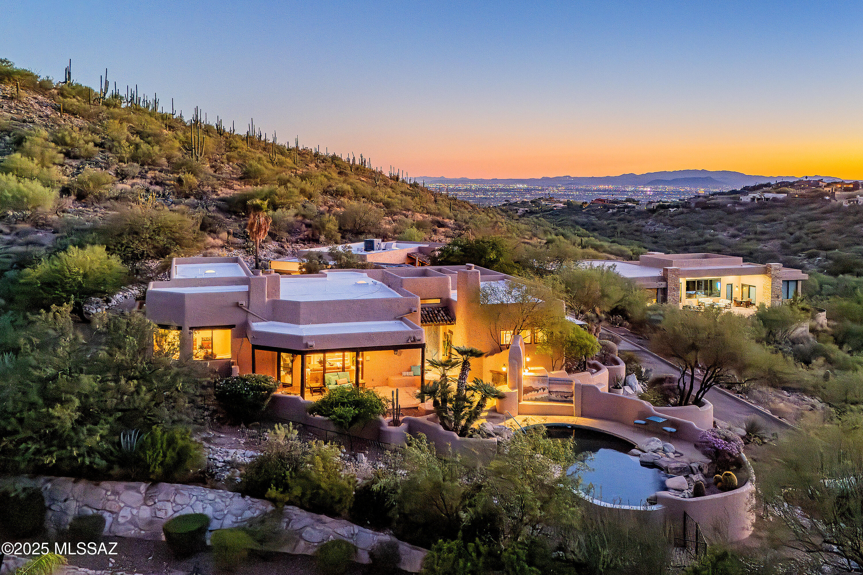 Nestled in the prestigious Alta Vista community, this exceptional residence sits atop a 1.21-acre lot, offering breathtaking mountain views. The main home spans 2,983 sq ft, complemented by a spacious 1,559-sq-ft guest house and a separate private office with its own entrance. This home features multiple living spaces, 5 bedrooms, 5 bathrooms, an office, and bonus room, providing ample space for family and guests. Many charming details, including soaring ceilings, exposed beams, and four fireplaces, create an inviting yet refined ambiance. Enjoy seamless indoor-outdoor living with two serene courtyards, multiple covered patios, and a sparkling pool. Located within the Catalina Foothills School District and just moments from premier golf, shopping, dining, and hiking.