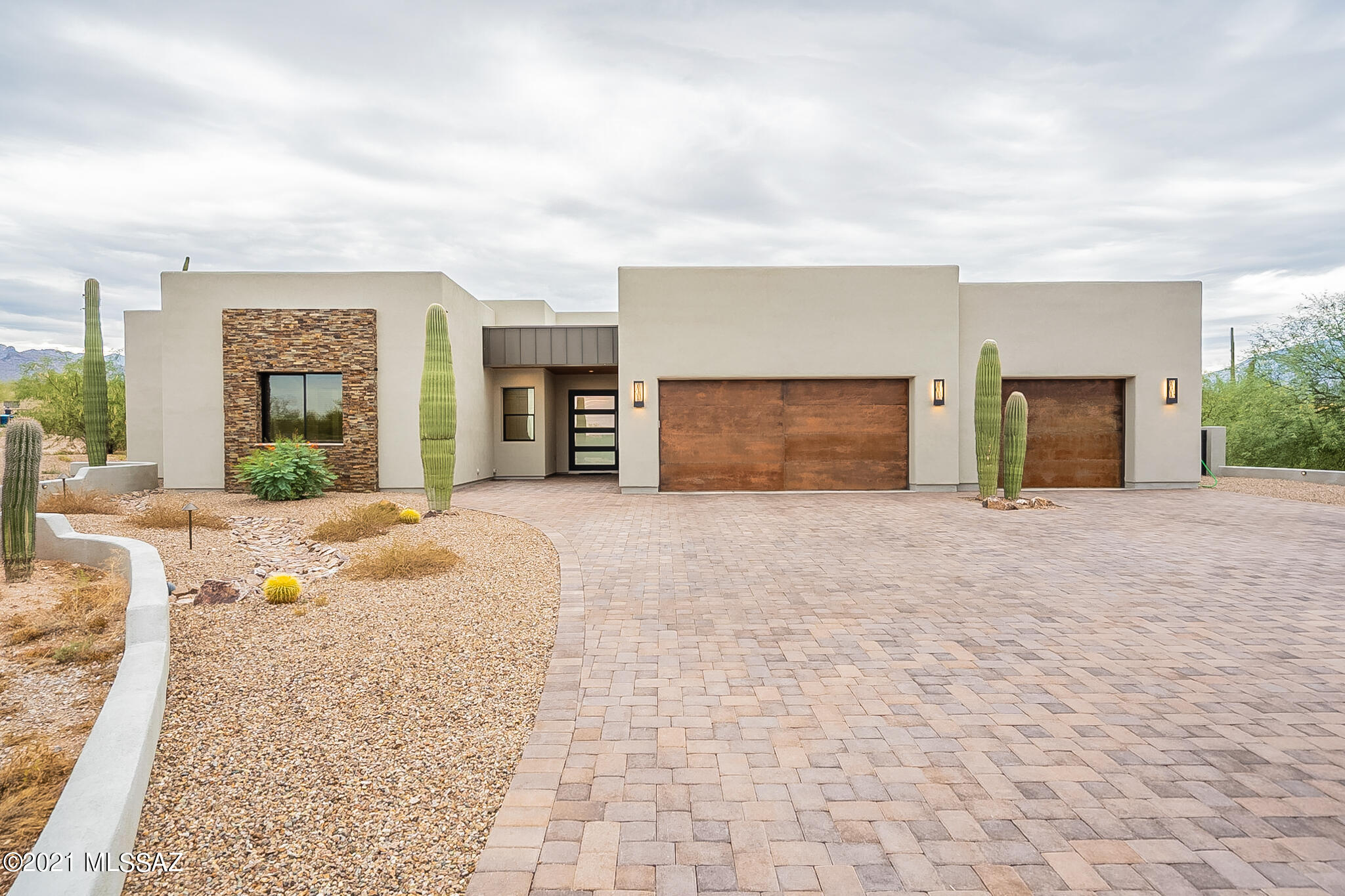 Stunning contemporary SW home on 1.7 acres calls you in thru frosted glass panel door to inviting great room w/fireplace & easy flow to open dining, beautifully appointed kitchen w/island, quartzite counters, gas cooktop, dbl ovens, apron front sink & built-in 48'' stainless fridge, media rm boasting 120'' projector screen, & ultimately, thru 12' slider to outdoor living w/built-in BBQ & ''cantina'' for time spent w/family & friends on expansive covered patio, in the solar-heated pool/spa, or at the firepit. Enjoy the views & desert life thru wrought-iron fencing. Nestle away for some respite in the 4bd, 3.5ba of this 3823 sqft split plan w/plank tile, LED & custom lighting, efficiently cooled by 16seer dual AC & solar powered. Add'l work space in massive 3-car garage w/copper front doors.