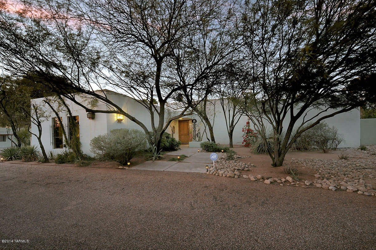 Soutwestern Contemporary in Colonia Solana has Magnificent generous living space w/brick flrs,hi ceilings & large windows. Livingrm has stacked stone Fireplace & overlooks a lush backyard. Gourmet's kitchen w/6 burner stove,tons of cabinetry,SS appliances, 8' Breakfast bar open to familyrm w/builtin theatre,atrium & screened patio. Master Suite has private bathrm w/jetted tub,tons of storage,double sinks,walk-in shower & screened porch. 2nd Mstr bedrm has private bathrm & walk-in closet.3rd bedrm adjoins office. Backyd has huge pool surrounded by ample patio space, covered patio & walled & private desert garden w/unique desert plantings large trees! 467 sq ft Guest qtrs has 2 rooms + 3/4 bath.  2 car gar/2 car-carport all on .96 acre lot