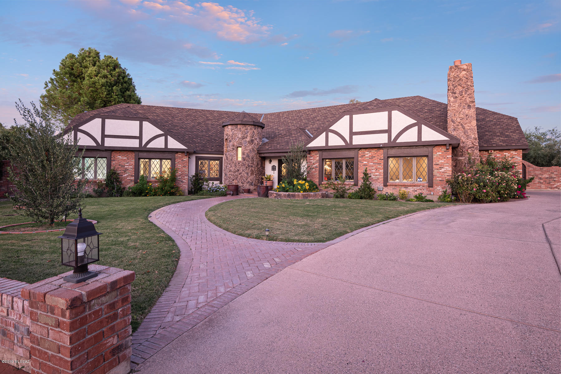 Located on a quiet cul-de-sac within the gates of Tucson Country Club, this rare Tudor home has been completely remodeled w/ no expense spared.  Winding pathway separates 2 lush lawns & leads to custom front door w/ dramatic & bright entry.  Open floor plan w/ spacious living rm area w/ FP, dining area w/ custom wet bar & kitchen w/ breakfast area that opens to family room w/ another FP. Incredible space for large-scale entertaining or spending time w/ family. Remodeled kitchen has 2 large skylights & granite counters, custom cabinetry, farm sink, stainless steel appliances & breakfast bar. Adjacent to kitchen is huge laundry room/mud room w/ storage. Master suite w/ FP has his & her closets, master bath w/garden tub/shower. Split bedroom floorplan w/ newly remodeled guest bath. East-facing backyard w/ deep covered patio, fenced in pool and spa and putting green.  2- car garage.