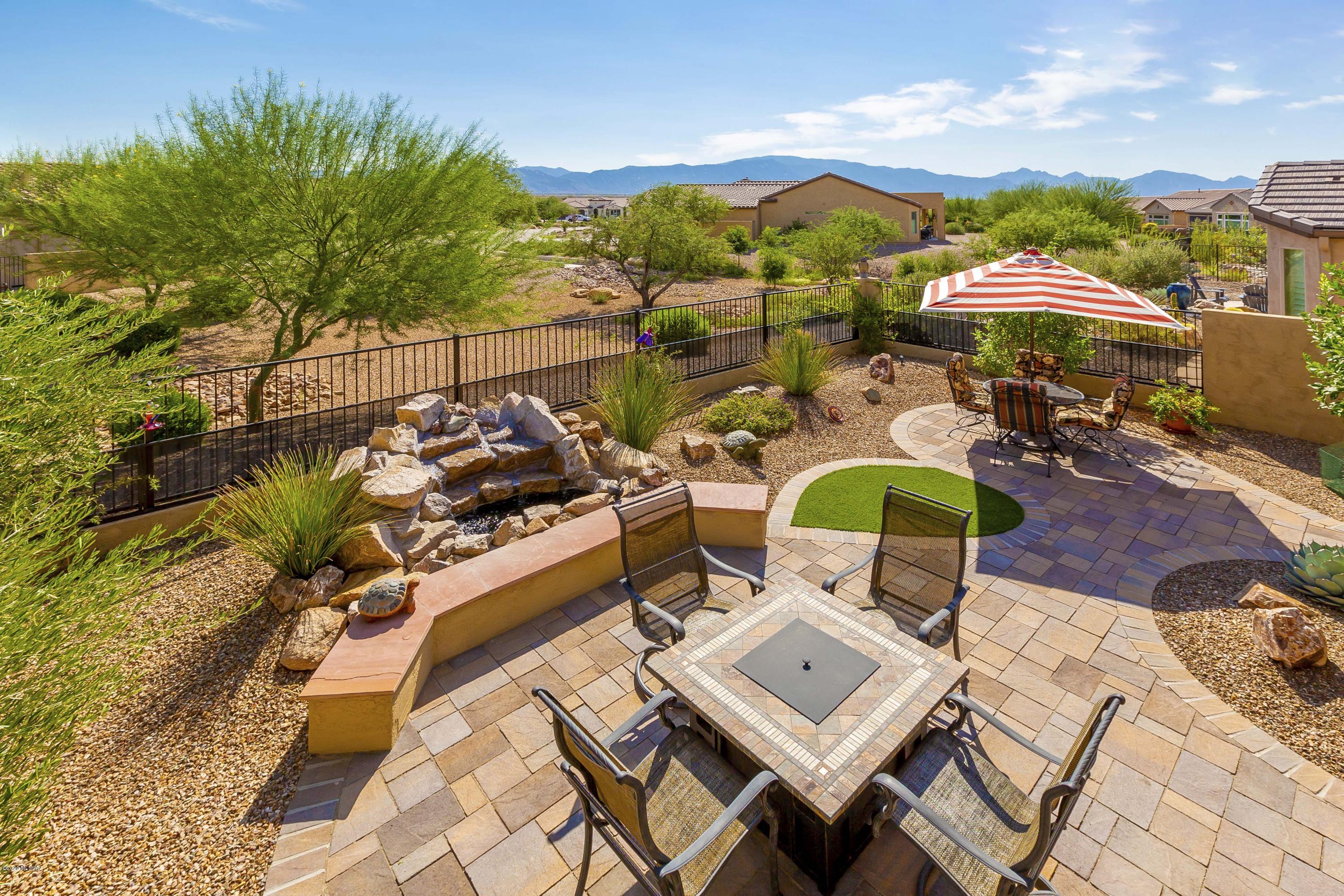 This popular Fresco model can be yours today!  Under 5 years old, this beautiful home offers a custom designed backyard with a splashing waterfall, outdoor kitchen, olive, orange, & lemon trees and upgraded sprinkler system. Ornamental wrought iron wildlife deterrent fencing is ideal for small dogs.  A stunning kitchen includes quartz countertops, large island, upgraded cabinets w/ roll out drawers. Enjoy extra living space with the extended Master Bedroom, Bar/Buffet, large Laundry Room.  Tile floors throughout. Custom front entry screen door.  4' extended garage w/epoxy floor & golf cart garage. Enjoy life at Saddlebrooke Ranch with the wonderful amenities of this premier 55+ community including golf course, pickleball courts, dog park, indoor & outdoor pools, restaurants,clubs and more.