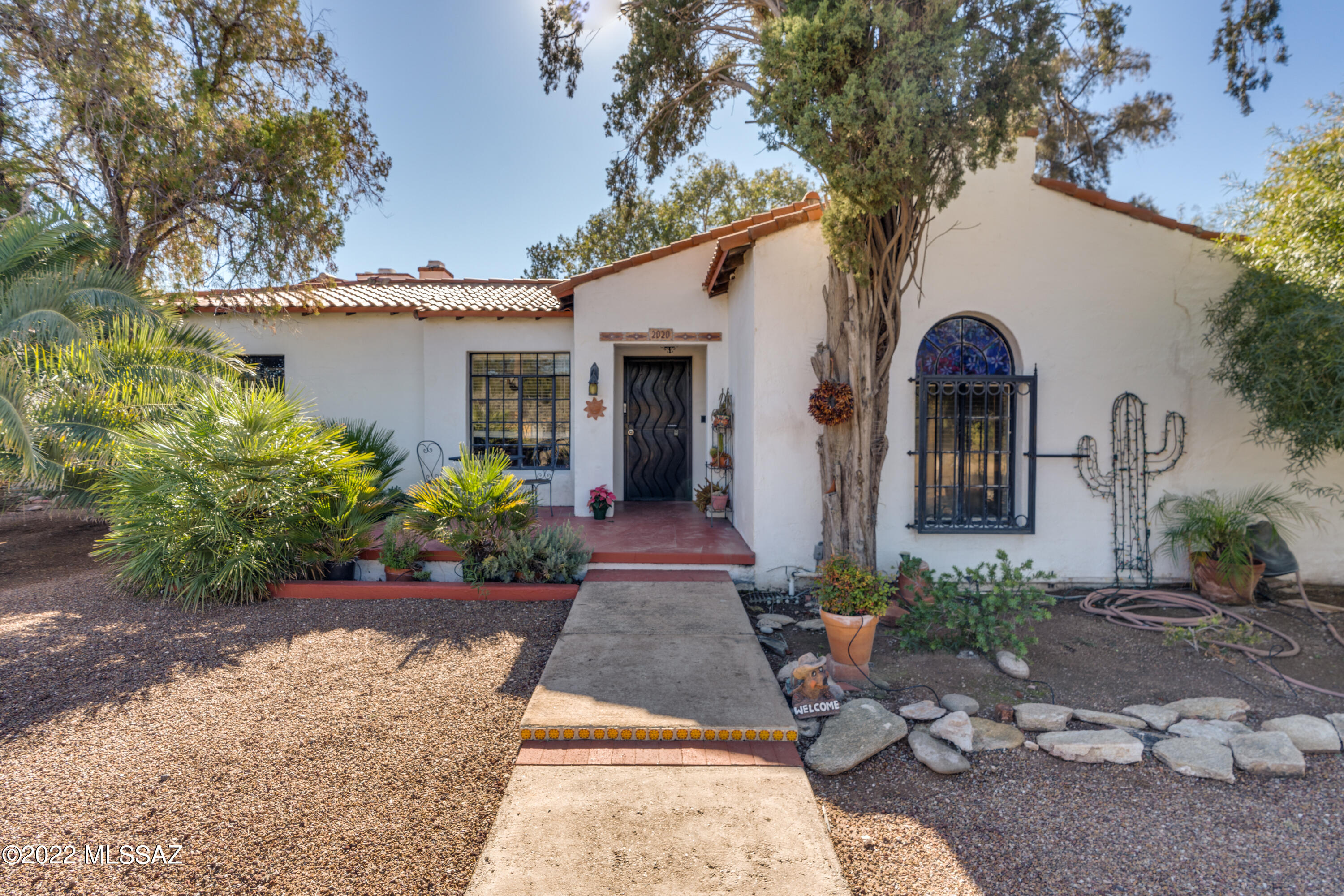 Beautiful historic property full of Sam Hughes charm, curb appeal & luscious grounds for a wonderful retreat in the middle of town, close to UofA. Sitting on a rare double lot, this property provides ample space, both inside & out. The main house includes 4 bedrooms & 4.5 bathrooms (all bedrooms with ensuite bathrooms), as well as unique art deco ceilings, original wood floors, high exposed beam ceilings, terrazzo tile great room, & two showstopper fireplaces that provide for a living space with great character. Guest quarters are split into two suites with individual heating/cooling systems – one currently functioning as guest quarters with bathroom & the other as office/storage space. This is a true gem, with so much to offer & great potential to make your own stunning Sam Hughes home!