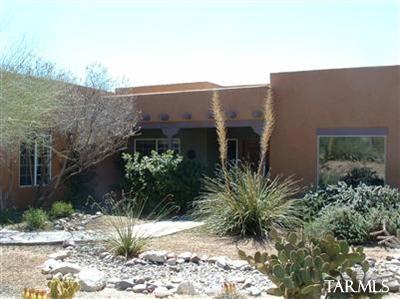Sante Fe style 4bdr/2ba home! Split floor plan, fireplace, flagstone patio, almost an acre of privacy and zero edge swimming pool! Formal LR and DR. Family room with eat in kitchen, beautiful natural desert landscaping